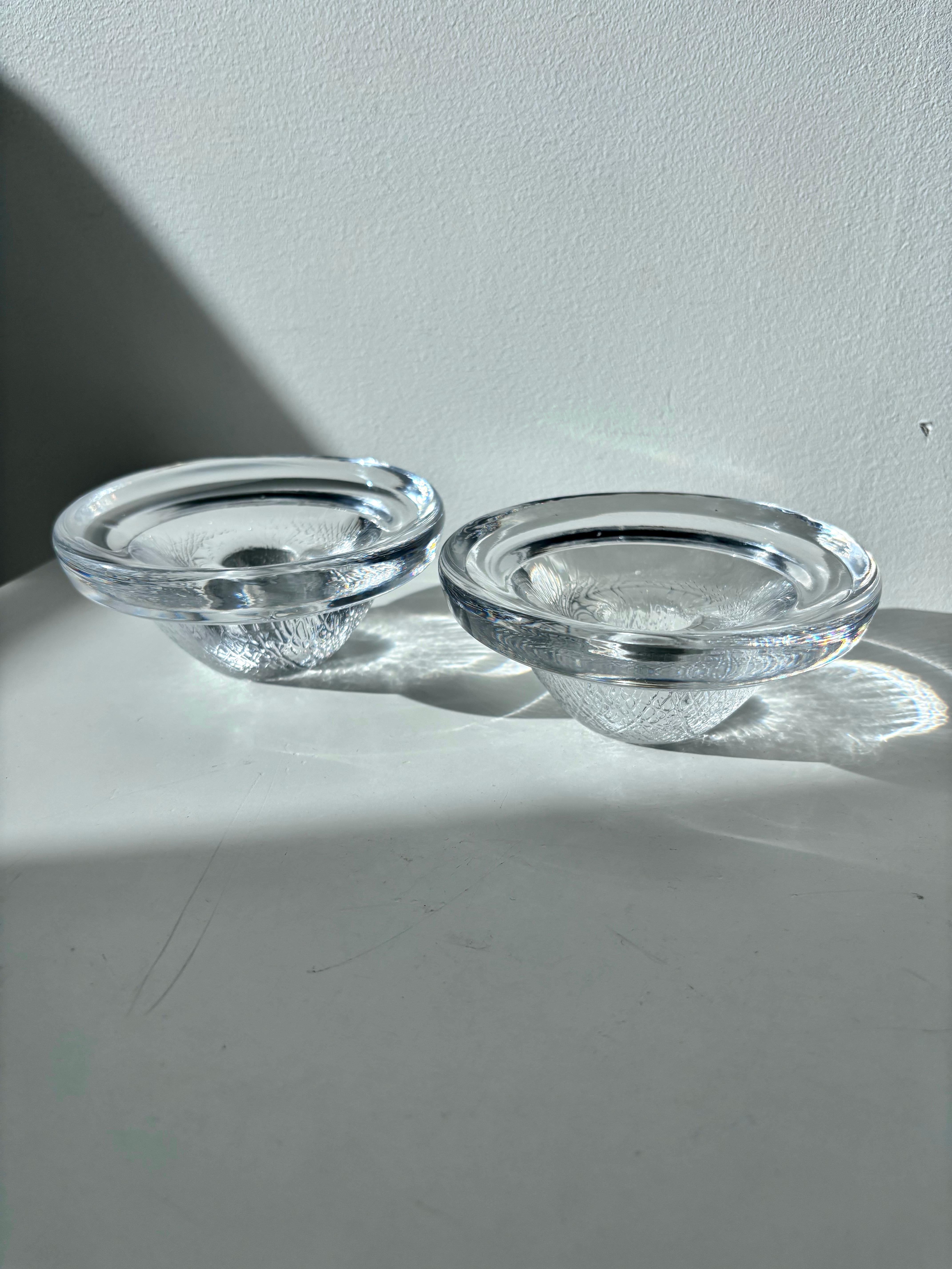 A beautiful pair of “Brava” glass candlesticks designed by the celebrated Swedish artists Ann & Göran Wärff for Kosta Boda. Hand-blown in Sweden, these sculptural pieces embody the Wärffs’ signature mastery of light, form, and craftsmanship.

Each