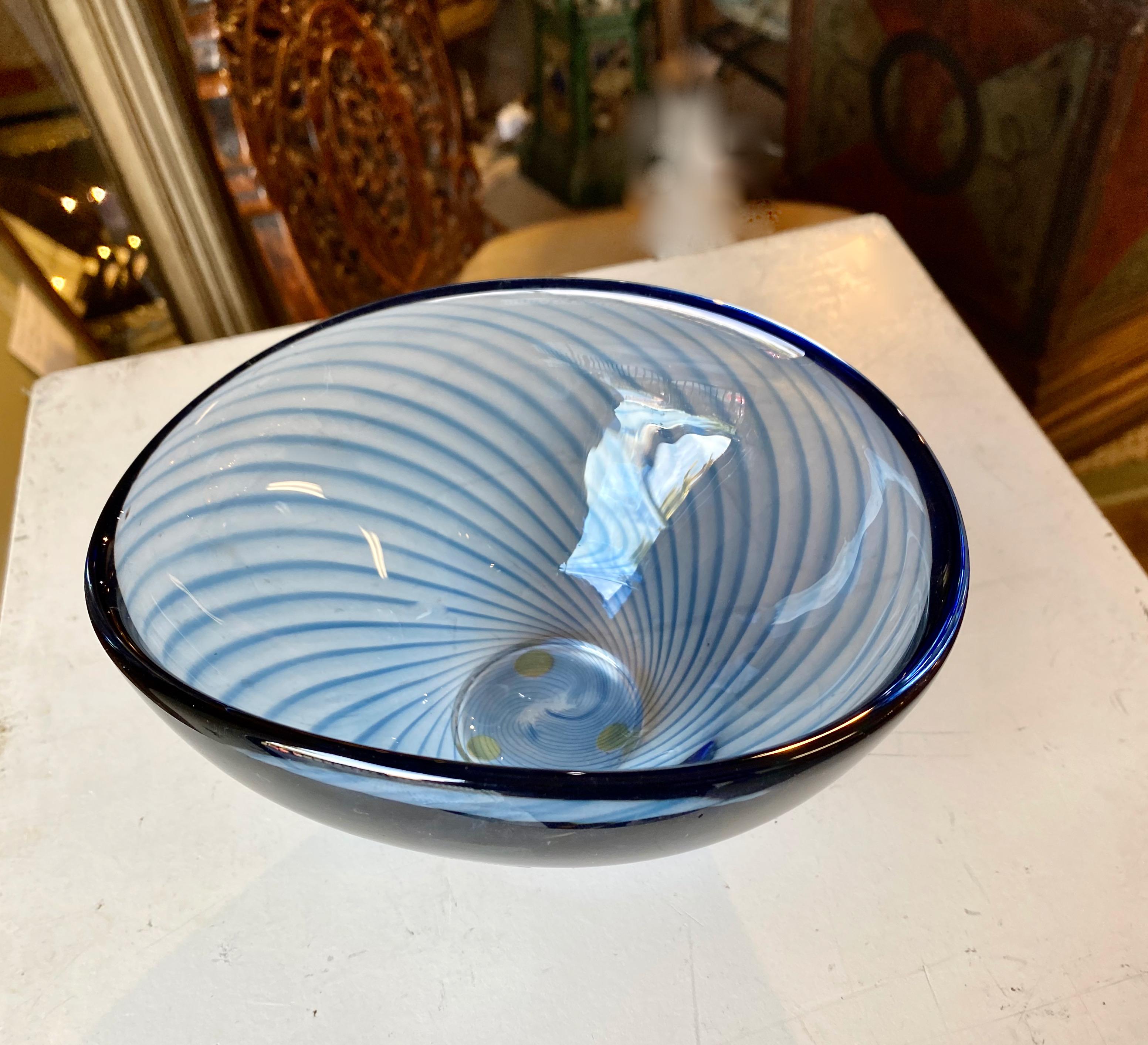 This is a beautiful mouth blown filigrana glass bowl whose design is attributed to Vicke Lindstrom for Kosta Boda. The bowl is of exceptional quality and is created in a stunning vibrant blue glass with filigrana detailing in a darker blue. Art