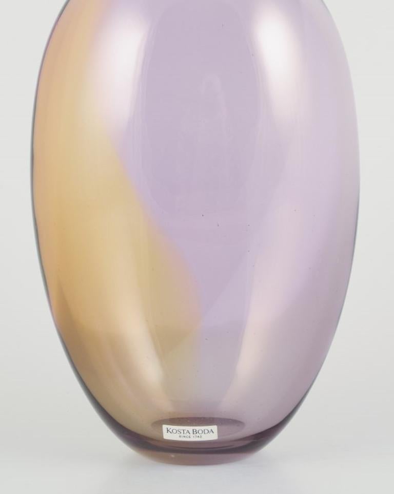 Kosta Boda, Svezia. 
Vaso in vetro artistico grande e dal collo sottile.
Soffiato a bocca. 
Vetro nei toni del viola e del giallo.
1980s.
Etichetta.
Condizioni perfette.
Dimensioni: Altezza 37,0 cm. x Diametro 12,0 cm.
