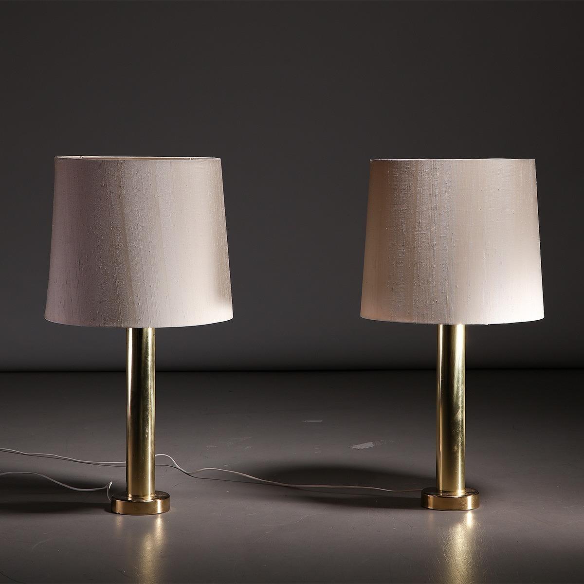 Pair of large mid-century Swedish brass and cotton table lamps made by Kosta Elarmatur in Sweden, 1970s.

These large and very elegant table lamps feature a tall brass stem and base, as well as a large cotton shade. They feature a very clean and