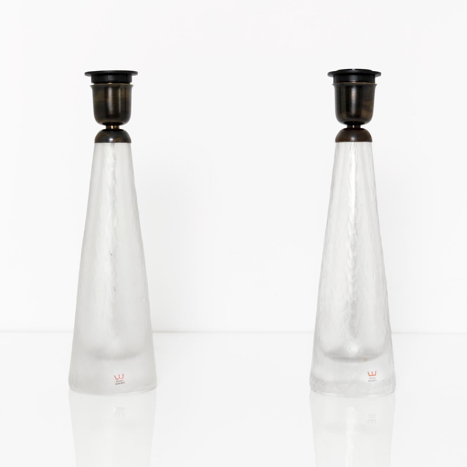 Ein Paar schwedische Glaslampen von Kosta aus der Mitte des Jahrhunderts, 1960er Jahre. Die Lampenkörper haben eine gemeißelte, säuregeätzte Oberfläche. Die Beschläge sind aus patiniertem Messing und für den Gebrauch in den USA mit je einer