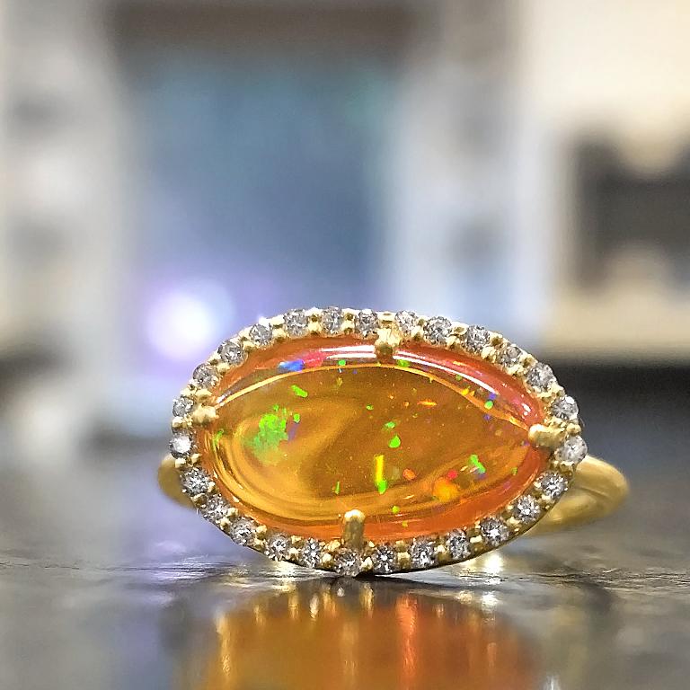 One of a Kind  Ring handcrafted by jewelry designer Tej Kothari in matte-finished 18k yellow gold featuring a gorgeous freeform Mexican fire opal surrounded by round brilliant-cut white diamonds. Size 6.5 (can be sized).

About the Maker - Kothari