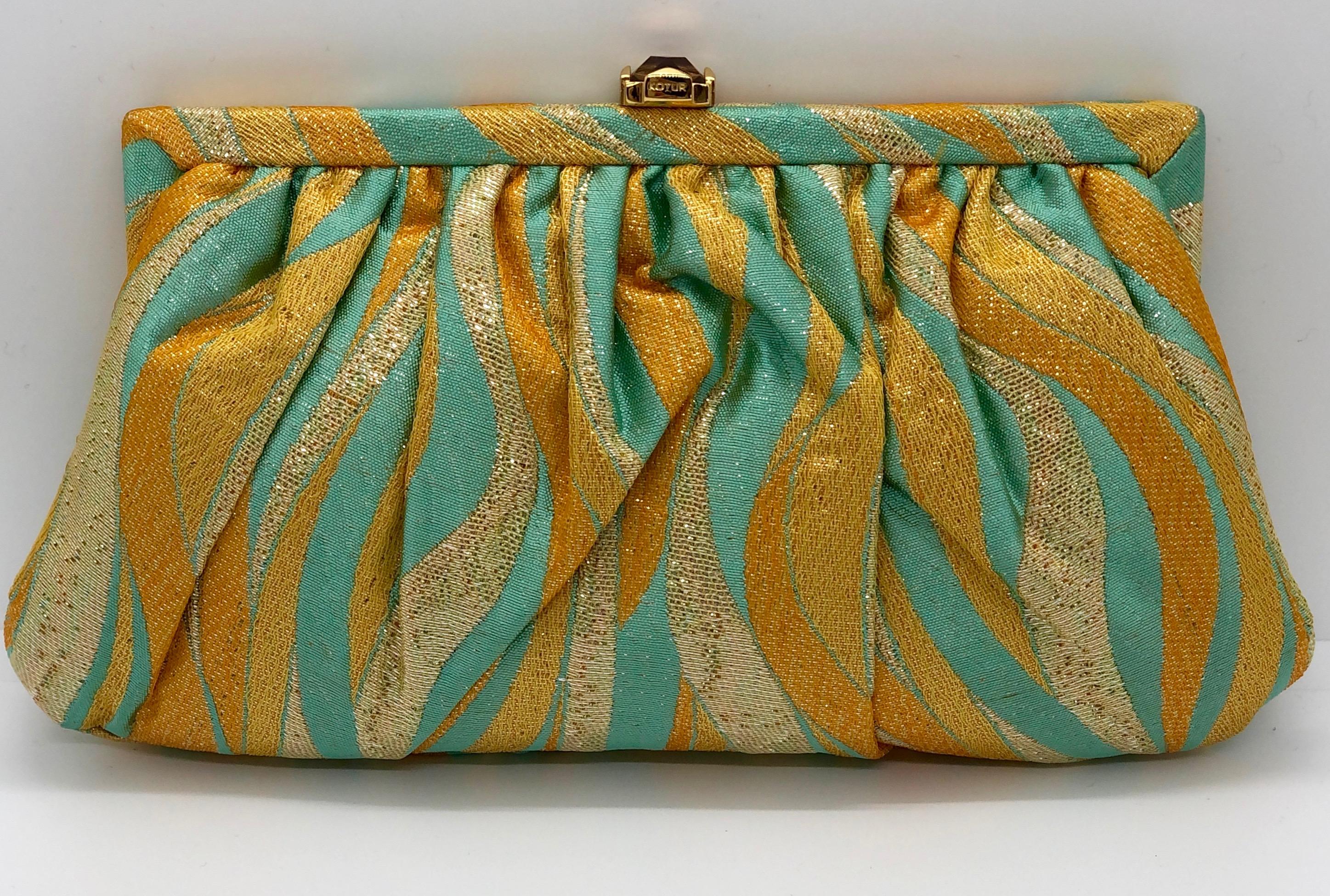 Manufacture:  Fiona Kotur
Place of Manufacture:  Hong Kong
Type:  Evening clutch with shoulder chain
Materials:  Metallic silk, cotton and leather interior
Colors:  Metallic corn silk yellow, gold and turquoise
Style:  Vintage silk and cotton