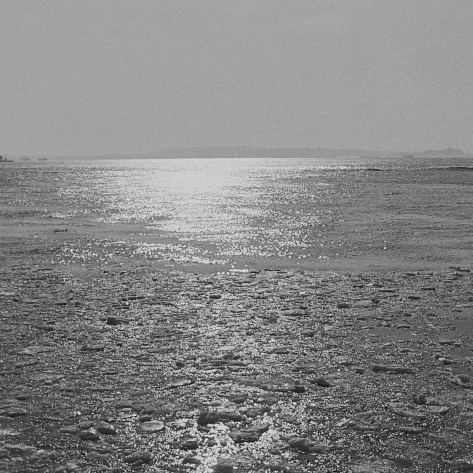 Untitled (0901-5A), Original Black and White Photograph, 2012
Black & white photograph. The composition frames the sunlight reflecting onto the water between two high contrast black columns. 

Artist Commentary:
In this stunning, classic photograph,