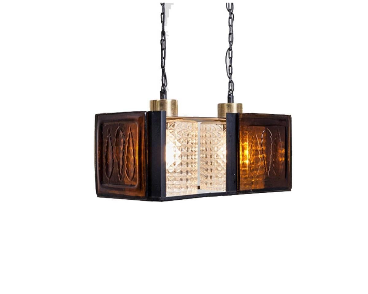 A big, bold and heavy pendant hanging from metal chains. Made by the Swedish designer and painter Erik Hoglund (Höglund) for Kosta Boda. The brown glass with textured leaves gives a nice warm 