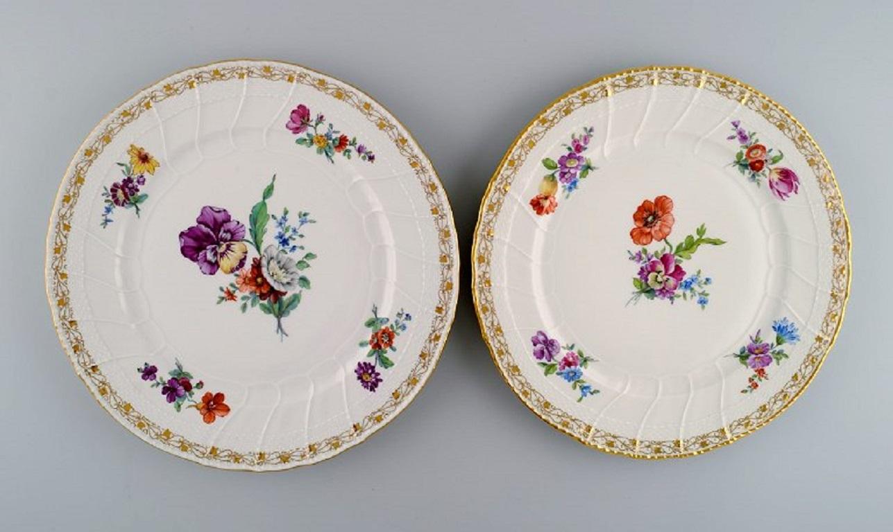 KPM, Berlin. Five antique dinner plates in curved porcelain with hand-painted flowers and gold decoration. 
Late 19th century.
Diameter: 26.5 cm.
In excellent condition.
Stamped.