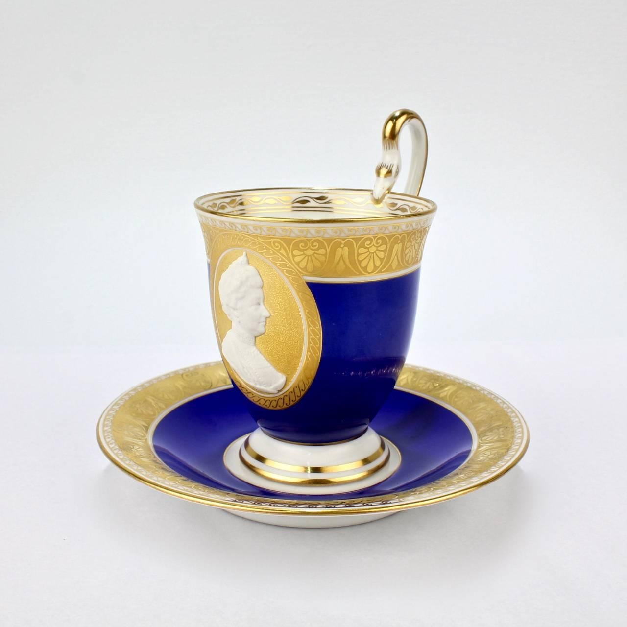 A wonderful and rare, antique KPM Royal Berlin cameo portrait cup and saucer.

The cameo relief bisque portrait depicting Empress Augusta Victoria is centered in a gold cartouche surrounded by a lapis blue ground.

Both cup and saucer have a