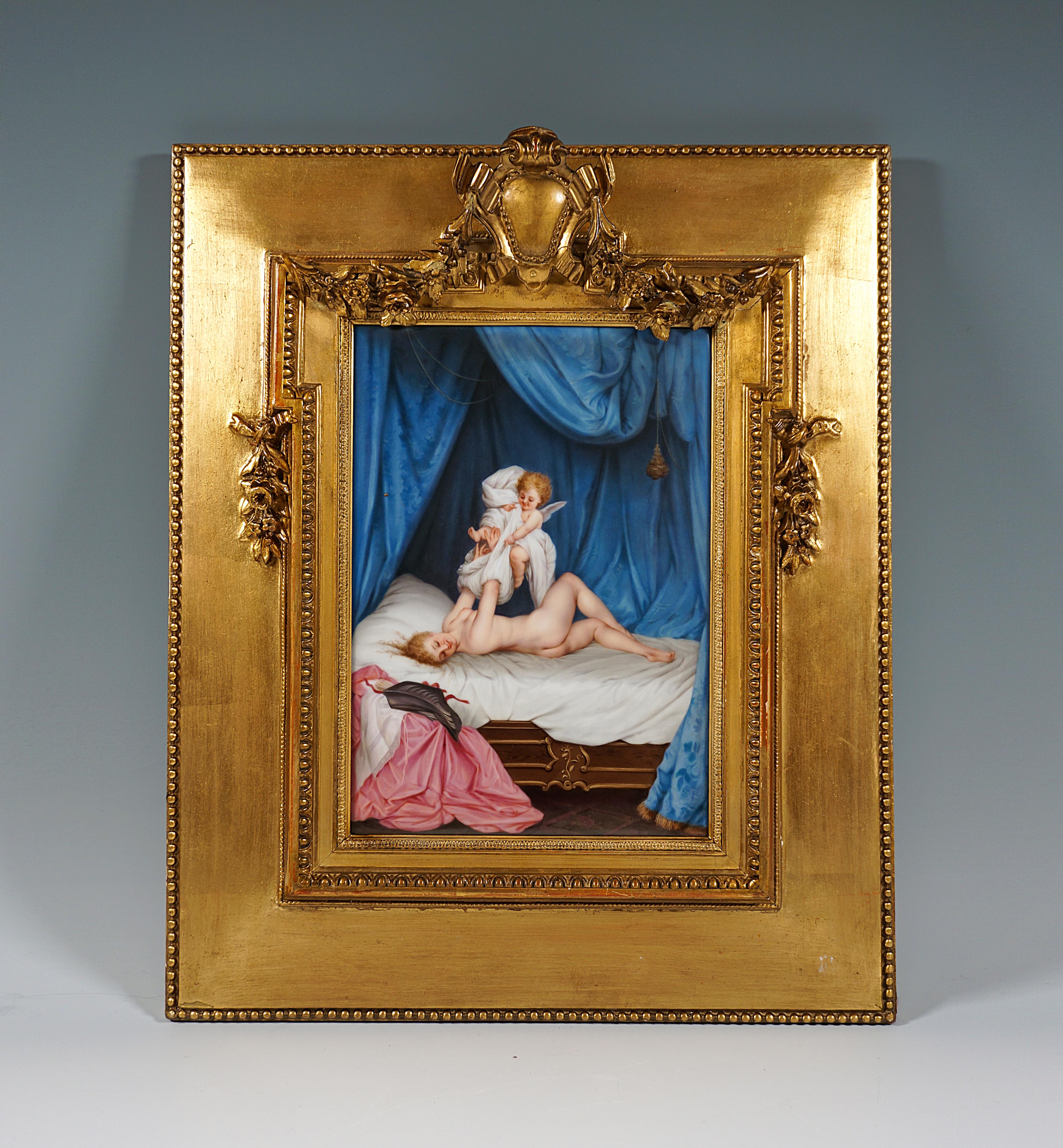 Exquisite erotic depiction of a young beautiful girl on a bed under elaborately draped canopy, being undressed by a winged cupid.
Fine polychrome painting on porcelain plaque in gilt wooden frame with pearl border and elaborately worked cartouche