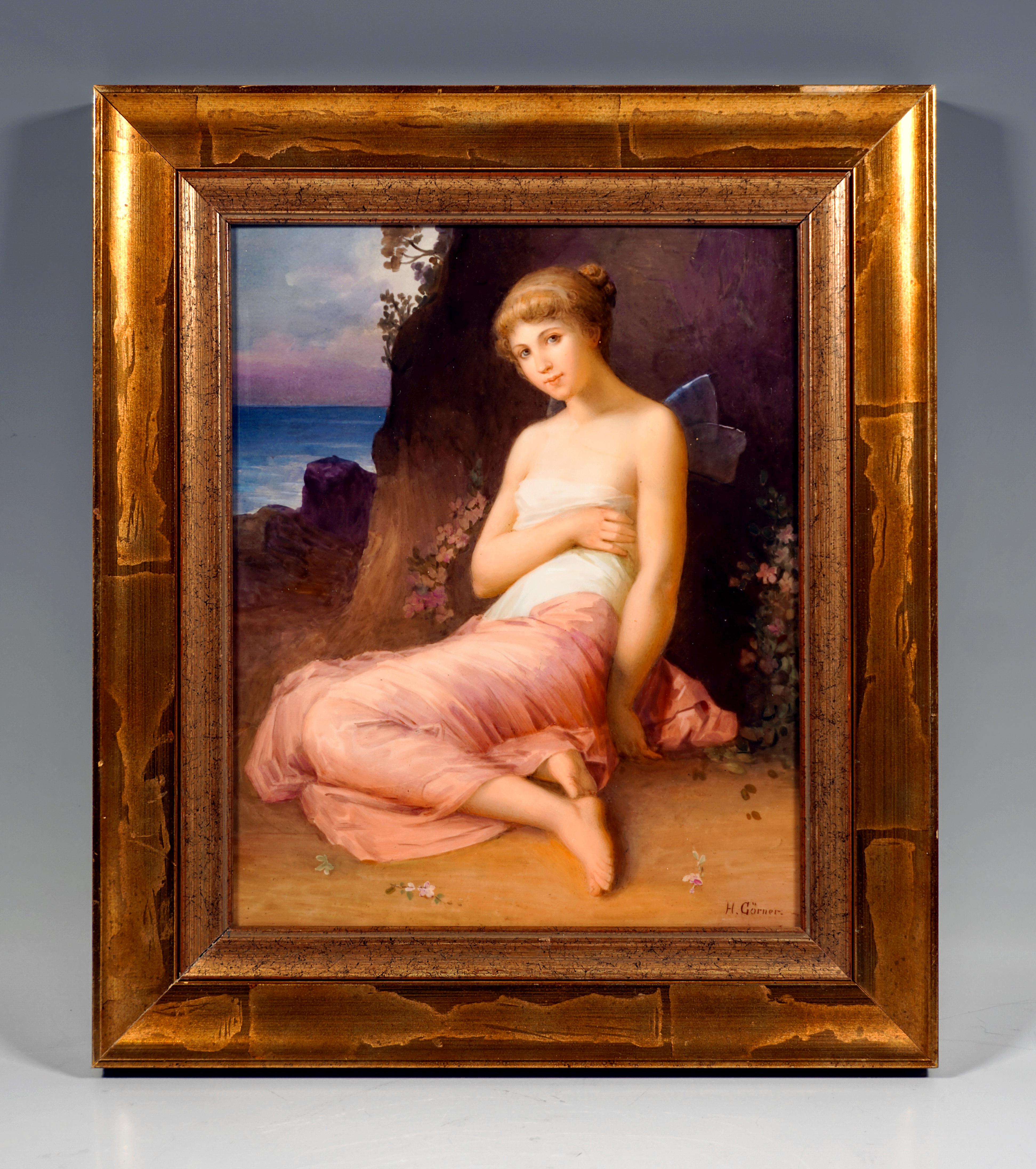 Delicate Porcelain Painting In Gilded Frame:
Exquisite depiction of a young, beautiful girl with her hair tied up and delicate, translucent wings, wrapped in fine, flowing pink and white cloths, leaning against a rock on the ground, surrounded by