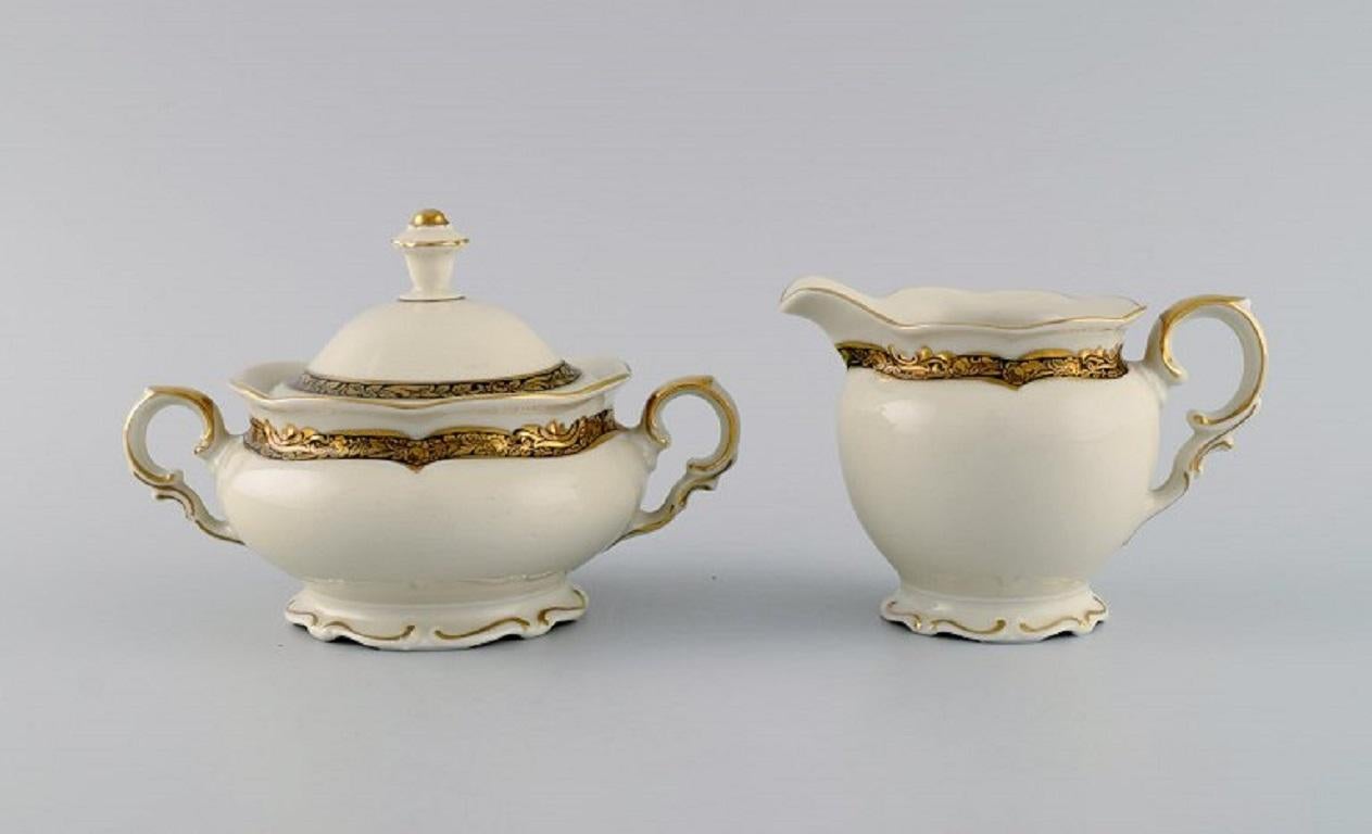 KPM, Berlin. Royal Ivory tea service in cream-colored porcelain with gold decoration for six people. 
1920s.
Consisting of six teacups with saucers, six plates, creamer and a sugar bowl.
The cup measures: 11.5 x 6.5 cm.
Saucer diameter: 16.5