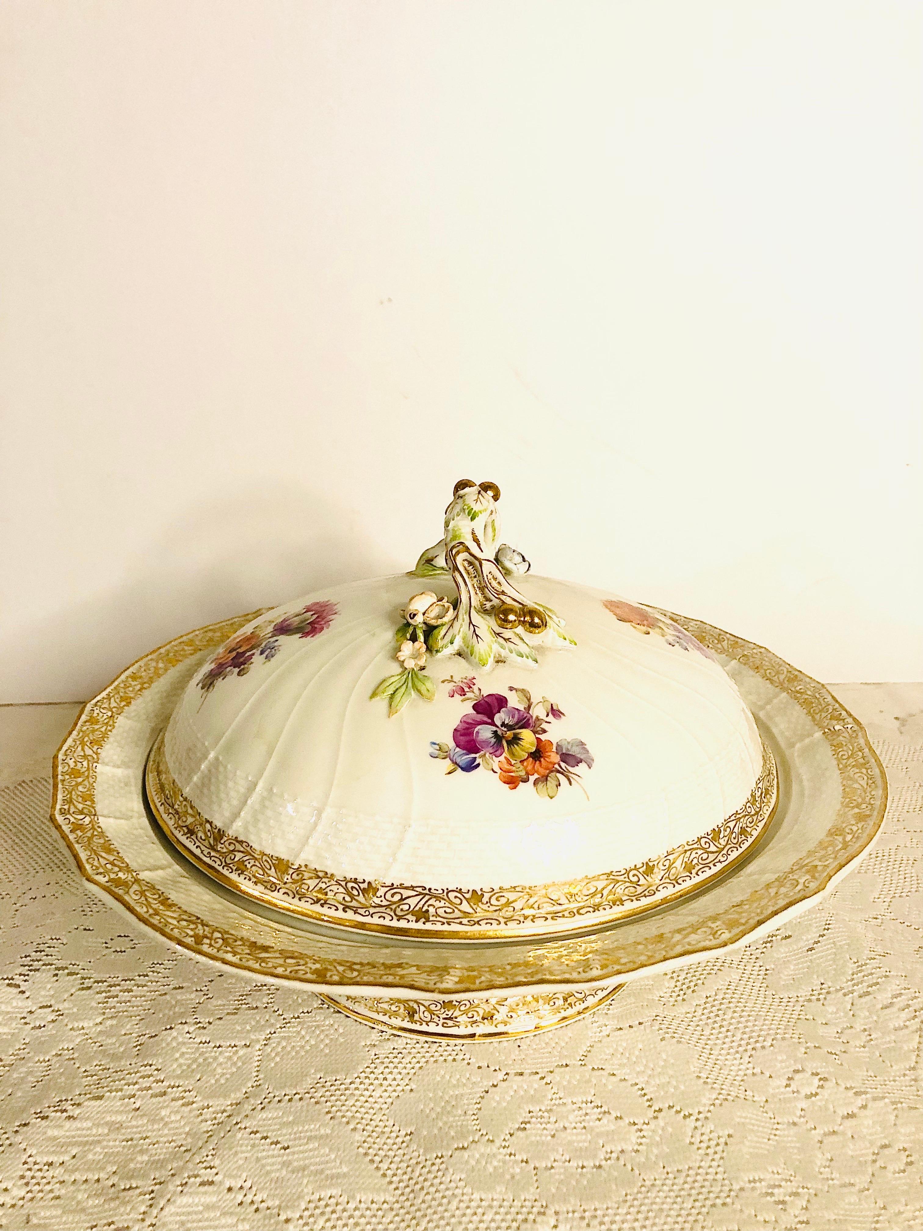 This is a very beautiful KPM covered bowl on a pedestal. The cover has four gorgeous hand-painted bouquets of flowers. The handle of the cover is decorated with raised gold cherries or fruit as well as raised roses in pink and blue with raised