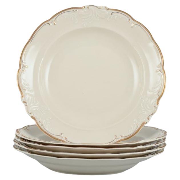 KPM, Polonia. Juego de cinco grandes platos hondos de porcelana de color crema.