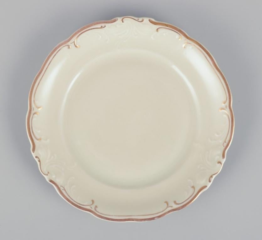 KPM, Poland. A set of nine cream-colored porcelain plates with gold decoration.
1930s/1940s.
Perfect condition.
Marked.
Dimensions: D 17.0 cm.