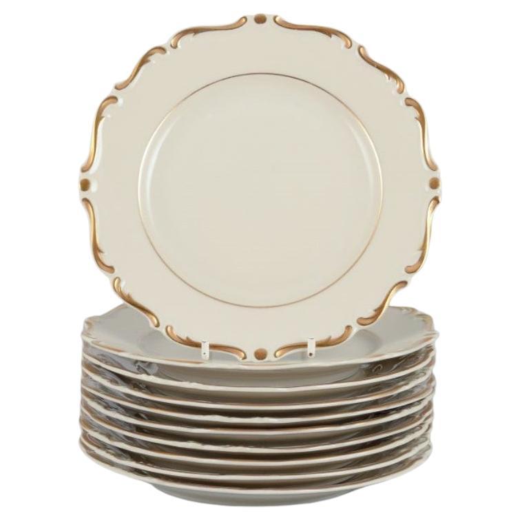 KPM, Poland. Set of ten cream-colored porcelain plates with gold decoration. For Sale