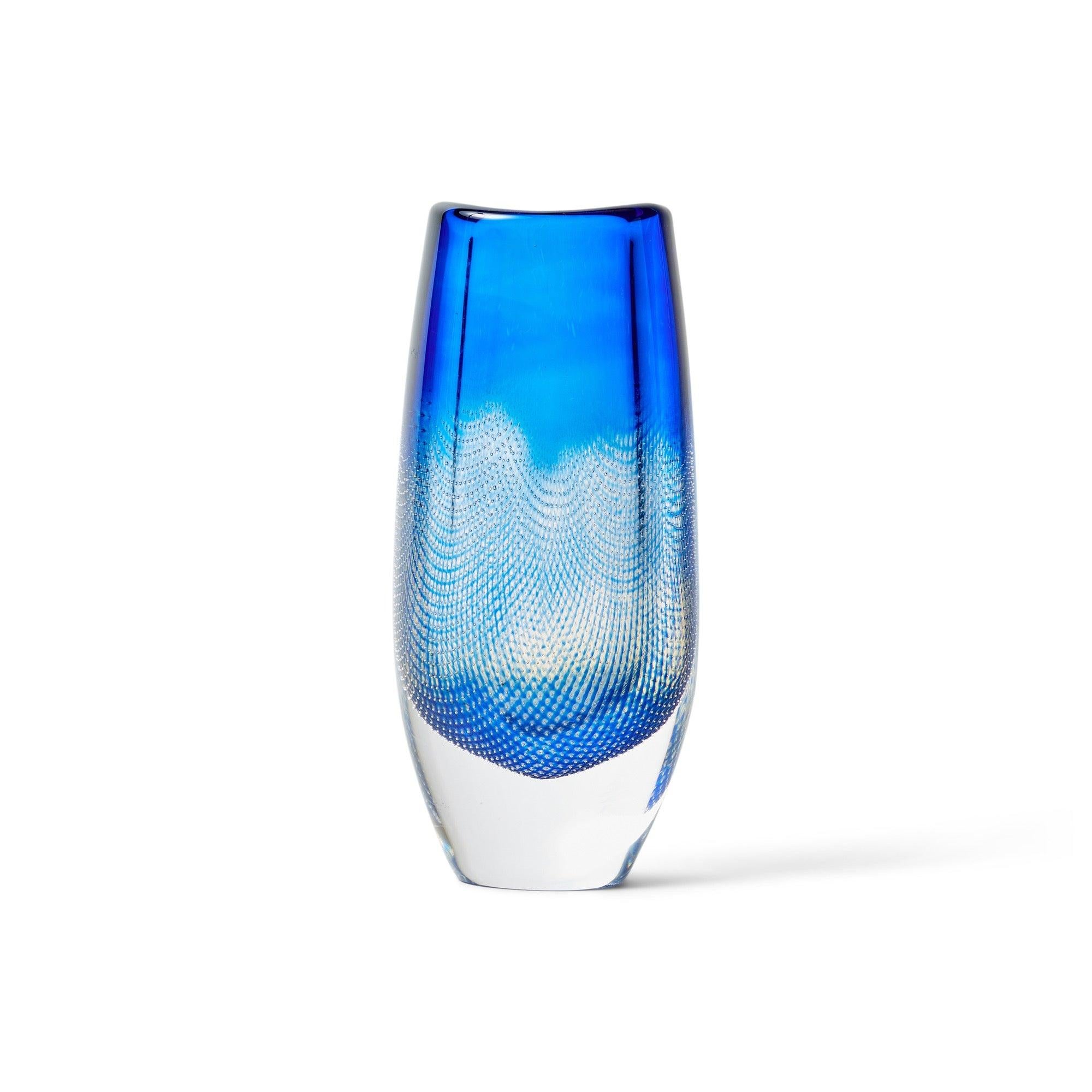 Un vaso soffiato a mano in vetro spesso e trasparente con sfumature di blu, che presenta un design a reticolo interno. Il lato inferiore reca la dicitura 