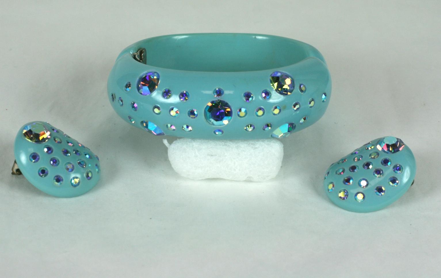 Kramer Bakelite Aurora Crystal Stone Suite with clamper bracelet and clip earrings. Pale blue plastic set with purplish Aurora crystal flashed stones. Festive sparkly suite from the 1950's USA.
Excellent condition.
Bracelet 1