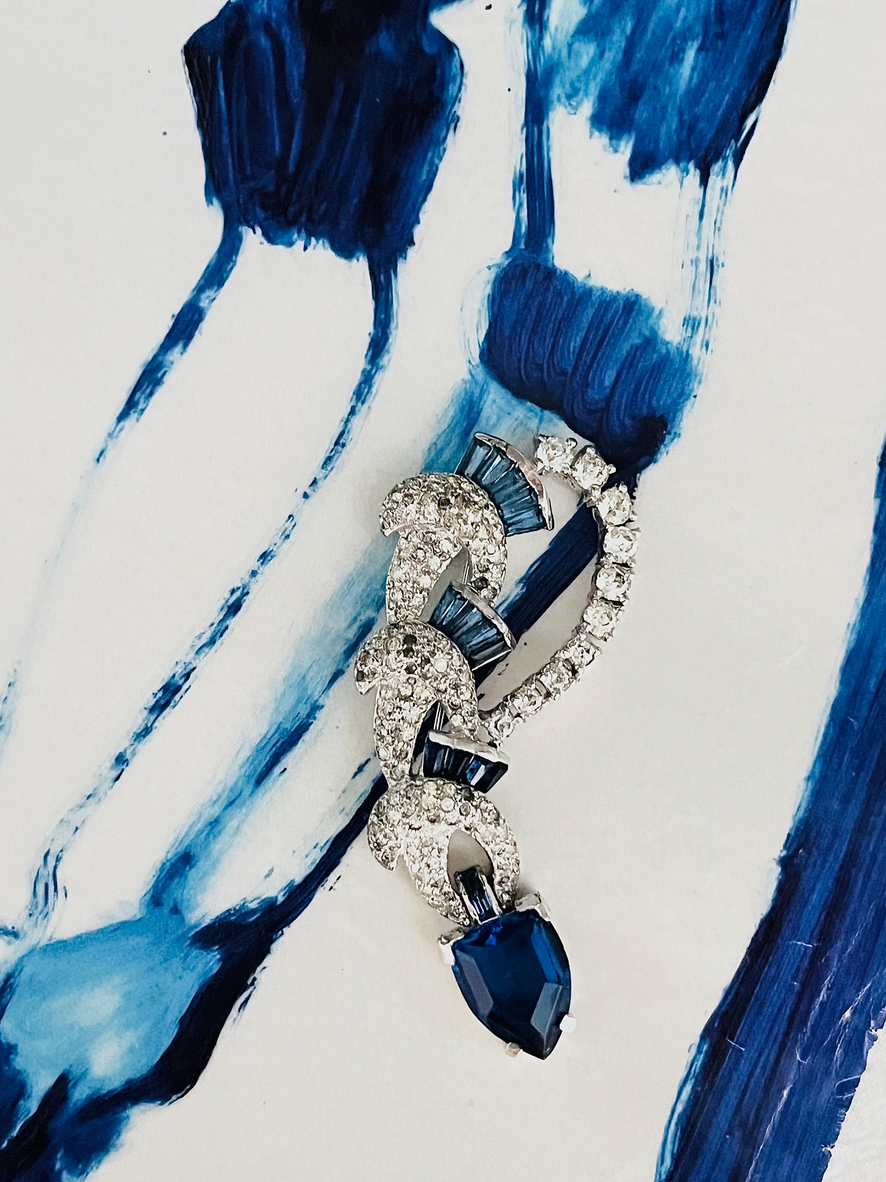 Kramer of New York Vintage 1950s Sapphire Navy Crystals Water Drop Knot Modernist Brooch, Gold Tone

Good condition. Some stones are shine off. Still very beautiful when wear it. 100% Genuine.

Signed at the back. Rare to find.

Size: 3.5*6.8