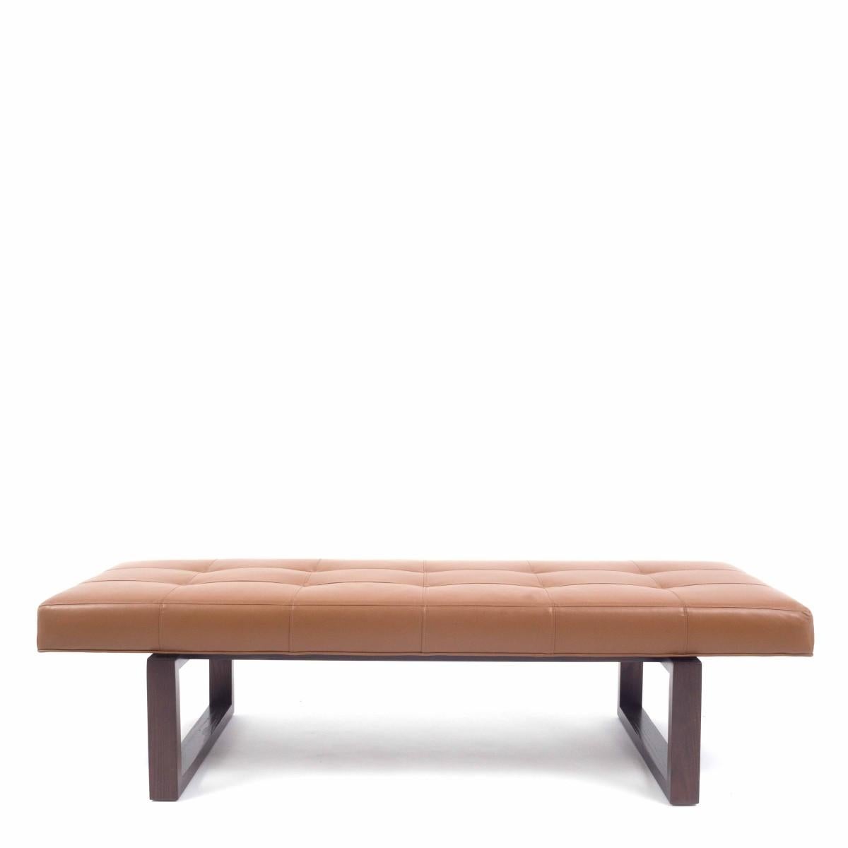 A handcrafted tan tufted leather bench with espresso-stained wood base by Kravet, circa 2010. 

Available in COM for additional fee; contact us for details.