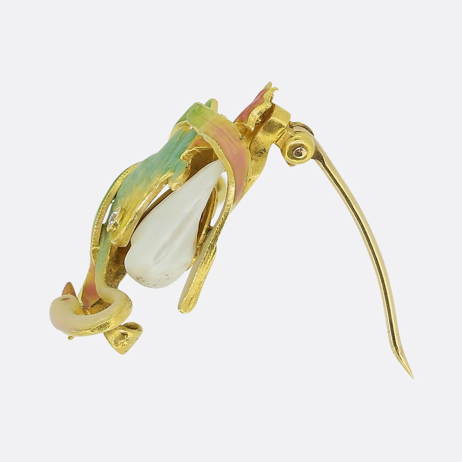 This is a splendid brooch from the world renowned American jewellery company Krementz. The brooch features  iridescent polychrome enamels that are archetypal of the Art Nouveau era and a natural freshwater pearl as the body. Although appearing
