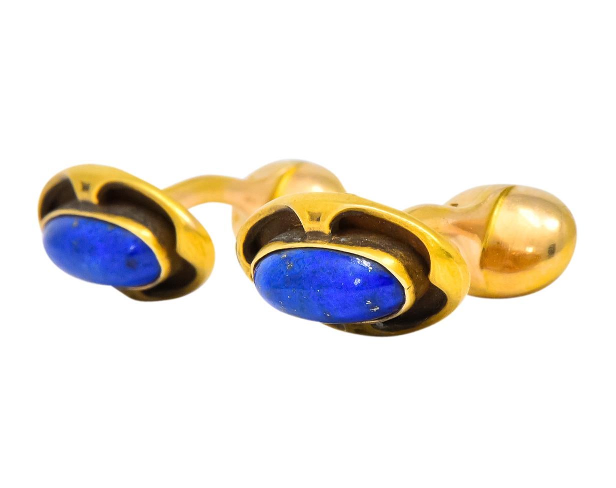Each centering an oval cabochon lapis, measuring approximately 12.0 x 5.0 mm, bright royal blue with small flecks of pyrite

Raised and bezel set with recessed and high polished gold surround

Fixed back style cufflinks

Stamped 14K with maker’s