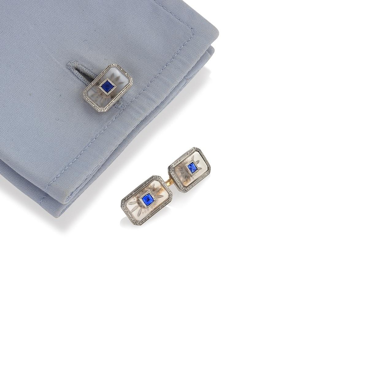An American Art Deco platinum and 14 karat gold, sapphire and rock crystal dress set by Krementz & Co.  The dress set consists of a pair of double sided rectangular cuff links set with center french-cut sapphires and 4 square dress studs made of