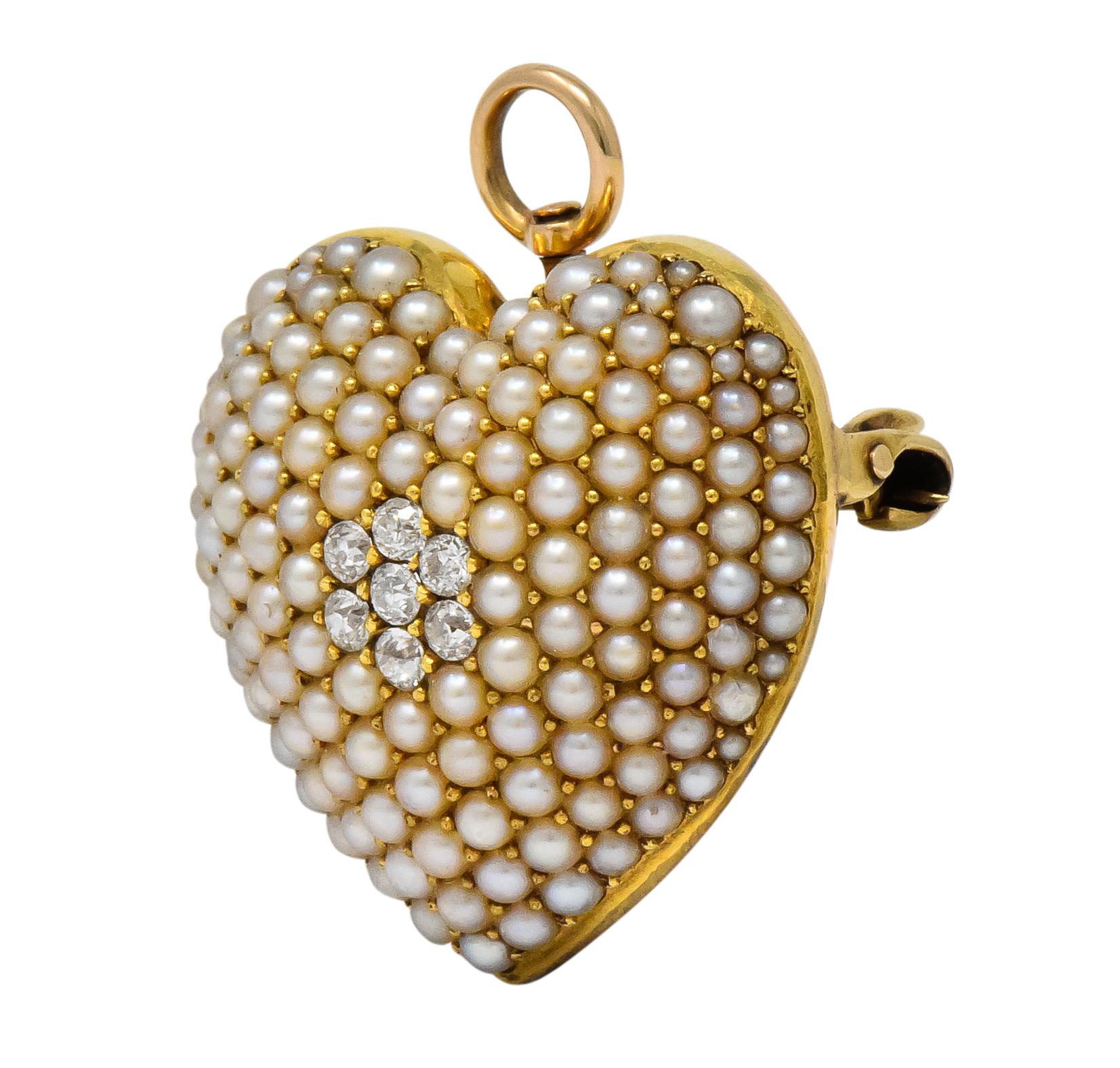 Designed as a domed heart centering seven old European cut diamonds, weighing approximately 0.15 carat total, eye-clean and white

On a field of white round seed pearls

With fold-down bale, pin stem and hook for a drop

Maker's mark for Krementz