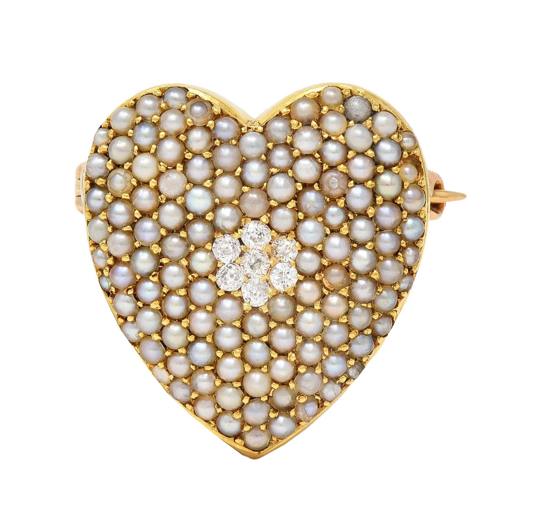 Designed as a domed heart-shaped form centering a cluster of old European cut diamonds
Bead set and weighing approximately 0.14 carat total - eye clean and bright
Accented by a clustered surround of pavé set seed pearls
Cream to gray in body color
