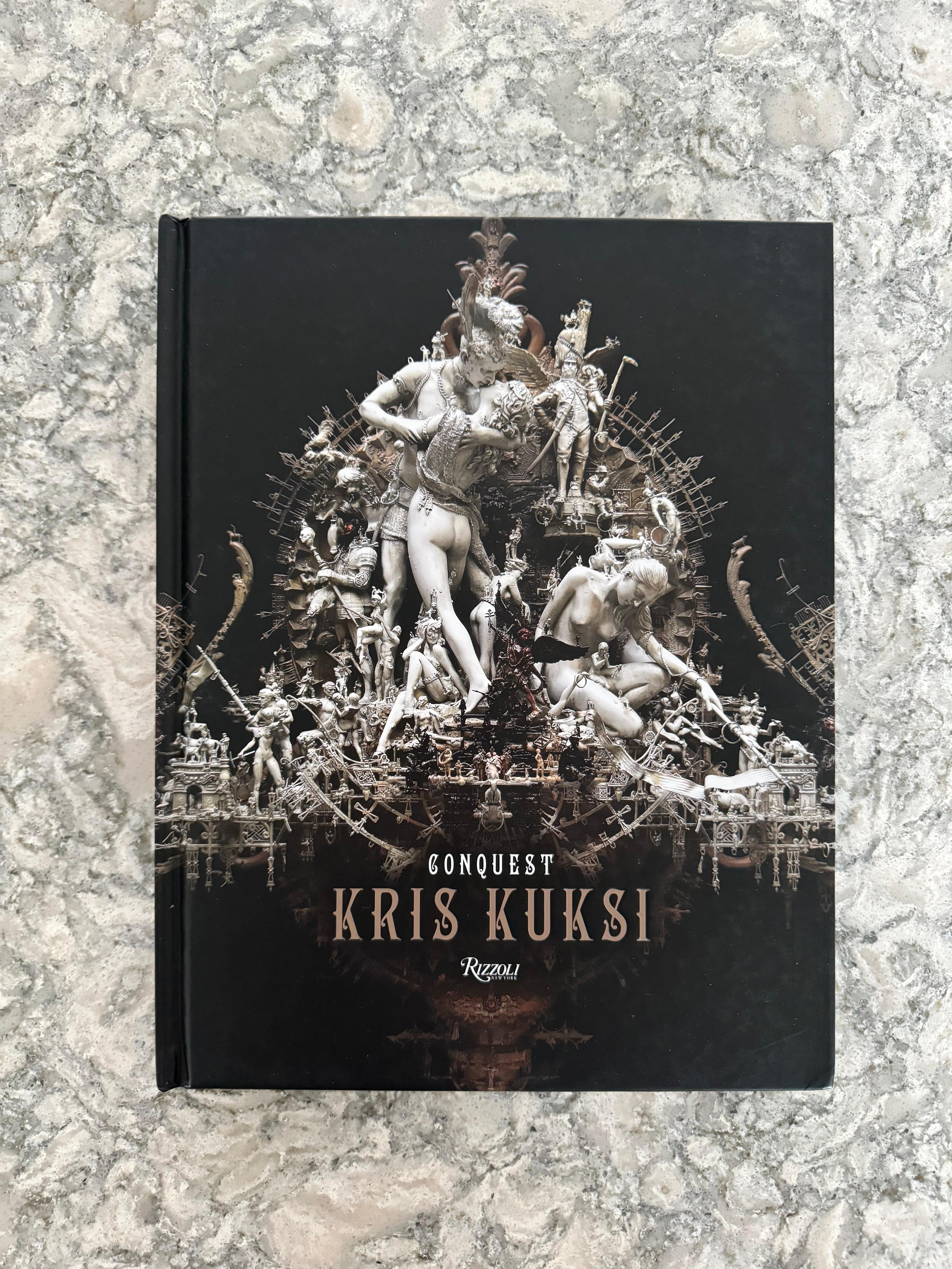 Conquest by Kris Kuksi - Signed Hardcover Edition

Book Description:
Immerse yourself in the captivating world of "Conquest" by Kris Kuksi, a stunning and evocative visual journey that transcends the boundaries of art. This limited signed hardcover