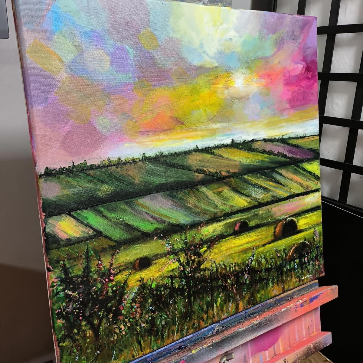 Original painting by Kris McKinnon. A view of hay bales on green hills under a colourful sky showing various pastel tones.

ADDITIONAL INFORMATION:
Original painting
Acrylic on canvas
Sold unframed
Complete size of unframed work: 50 H x 50 W x 2 D