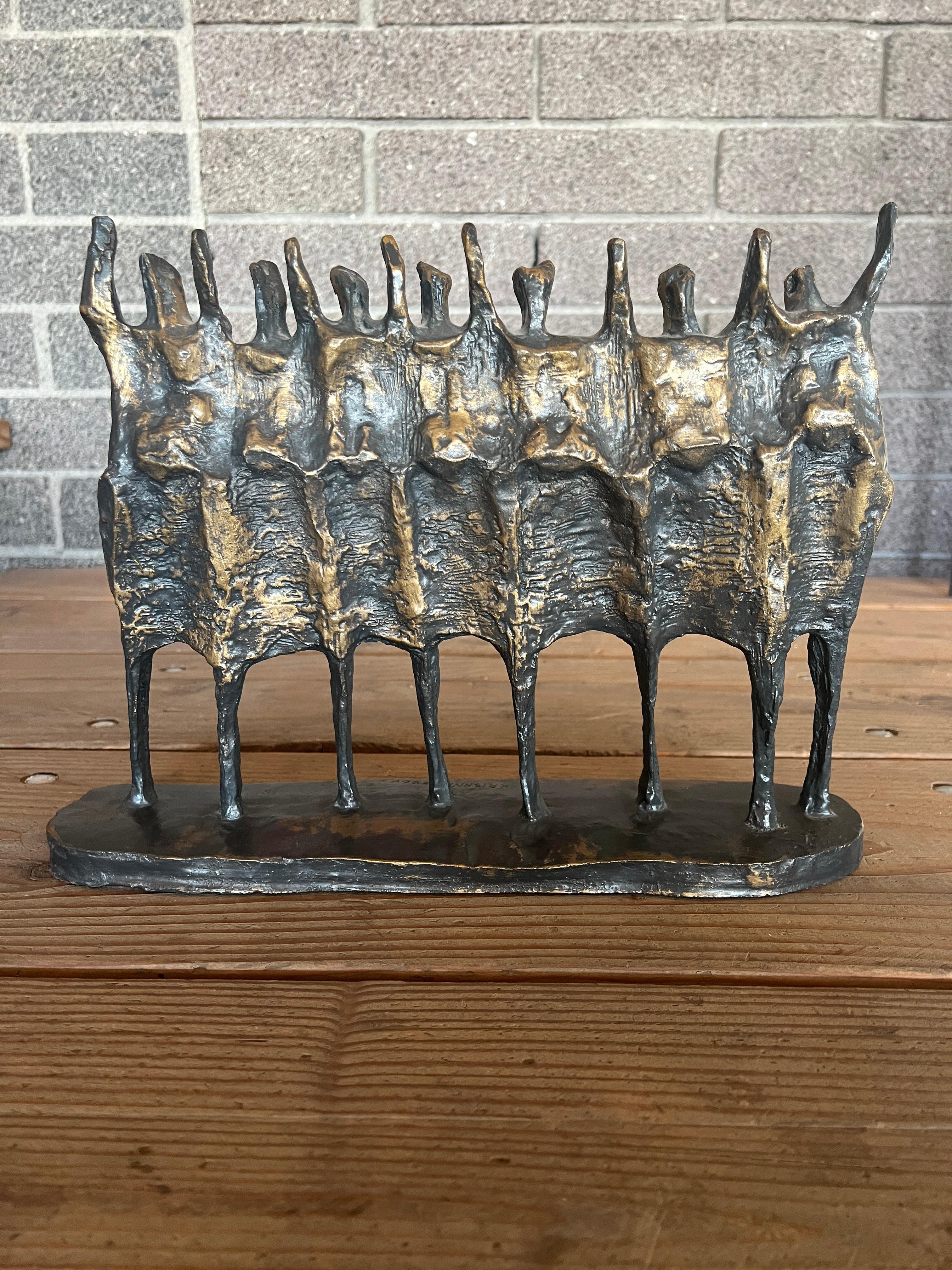 Figural brutalist style resin sculpture by Krishna Reddy circa late 1970's. The artwork shows a line of abstracted figures with arms raised with a rich bronze-like patina. The artist's signature can be found on the base of the sculpture. 