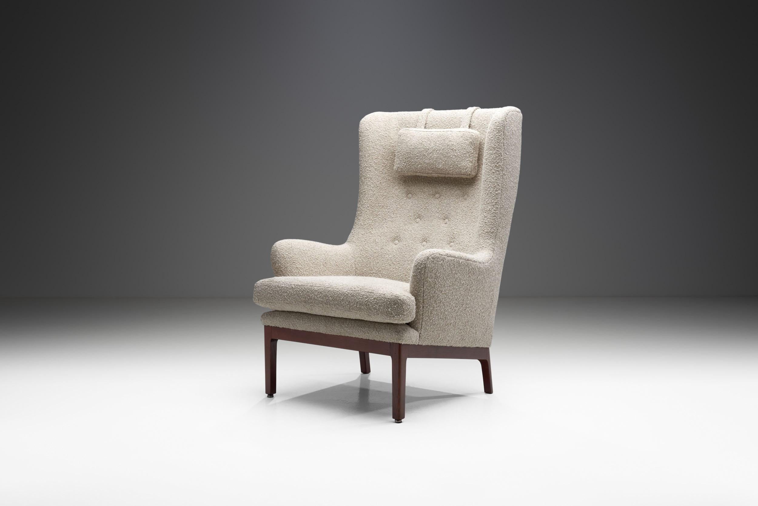 This “Krister” armchair is among Swedish design icon Arne Norell’s cosiest works. This high-back armchair’s comfort is equalled by its stylishness and elegance.  

The chair is raised on a stained wood frame covered by beautiful, light coloured
