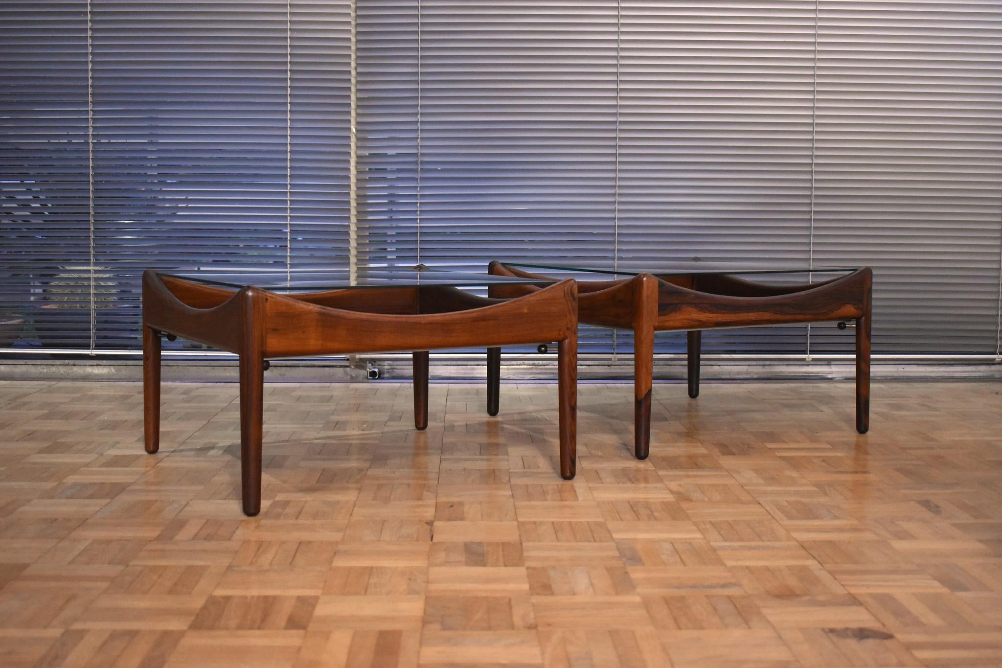 A pair of Brazilian rosewood, steel and glass coffee/end tables designed as part of the Modus range of furniture by Kristian Vedel, produced by Soren Willadsen, Denmark.

It is very hard to find such original and complete tables as these. Beneath