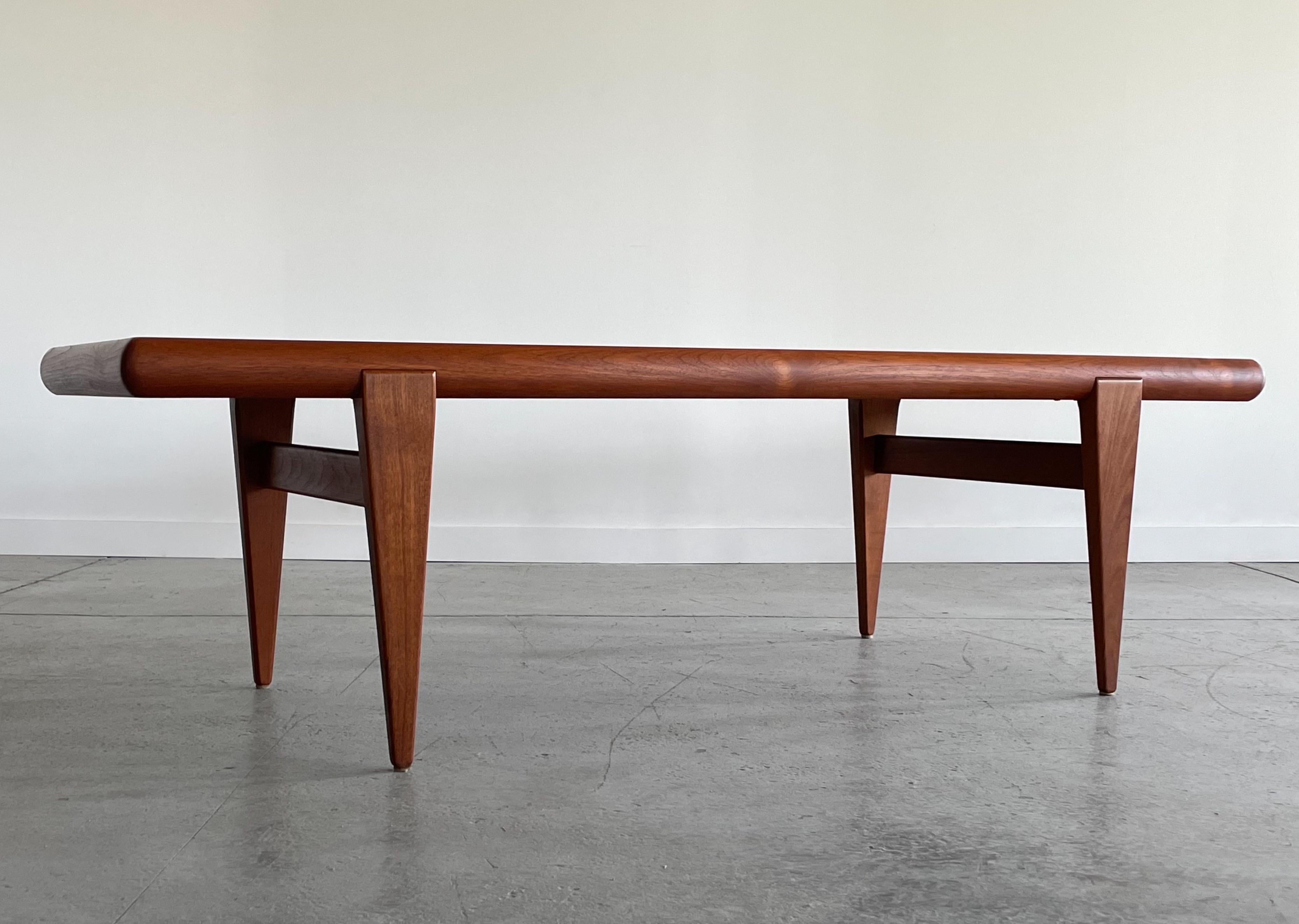 Sculptural teak coffee table by Kristiansen & Thomassen, Denmark. This piece has a substantial profile and features a thick top with contoured edging, and a nicely sculpted leg detail. This unique design is very sturdy and in excellent restored
