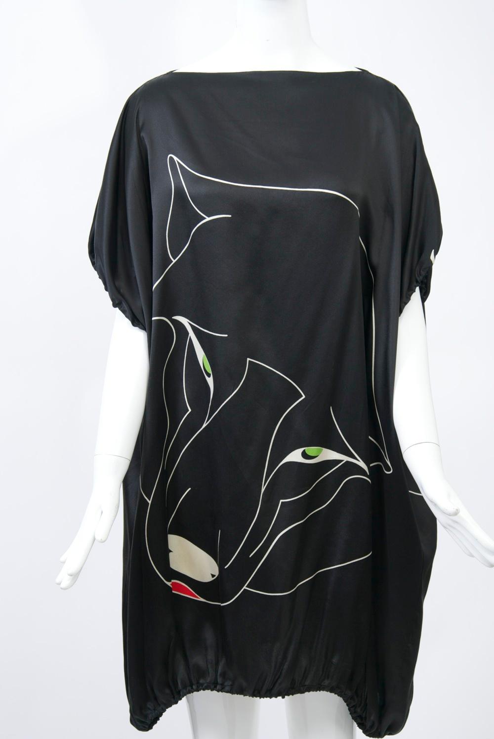 Krizia black silk tunic printed with large white outline of a big cat, accented with green eyes and a red mouth. Straight, loose cut with dolman, short sleeves elasticized at hem, as is tunic. Keyhole opening in back. Free size.
