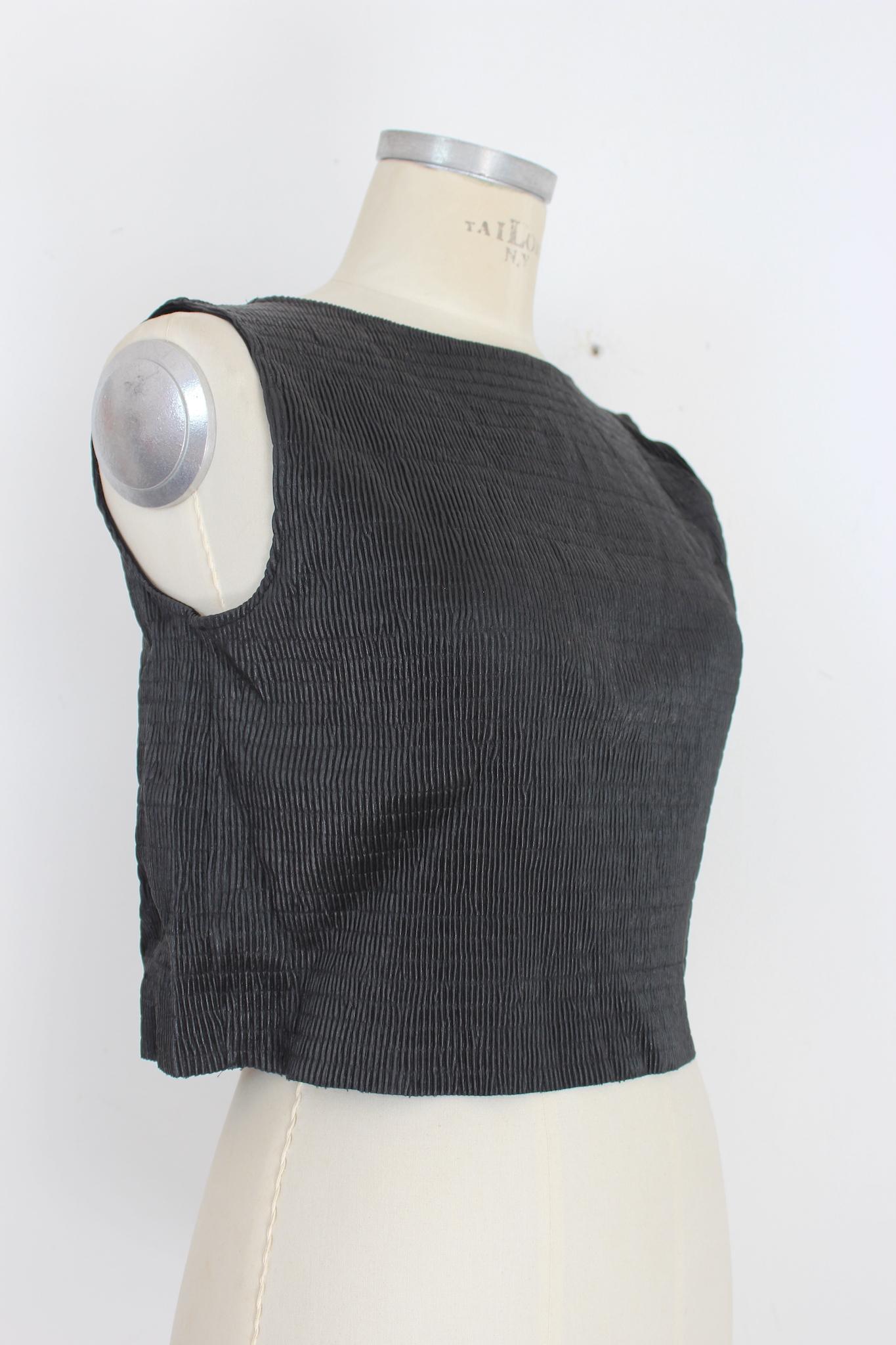 This vintage Krizia top from the 80s is a unique and edgy addition to any wardrobe. Made from high-quality faux leather, the black top features intricate pleating details and a short length. The cropped design adds a touch of sophistication while