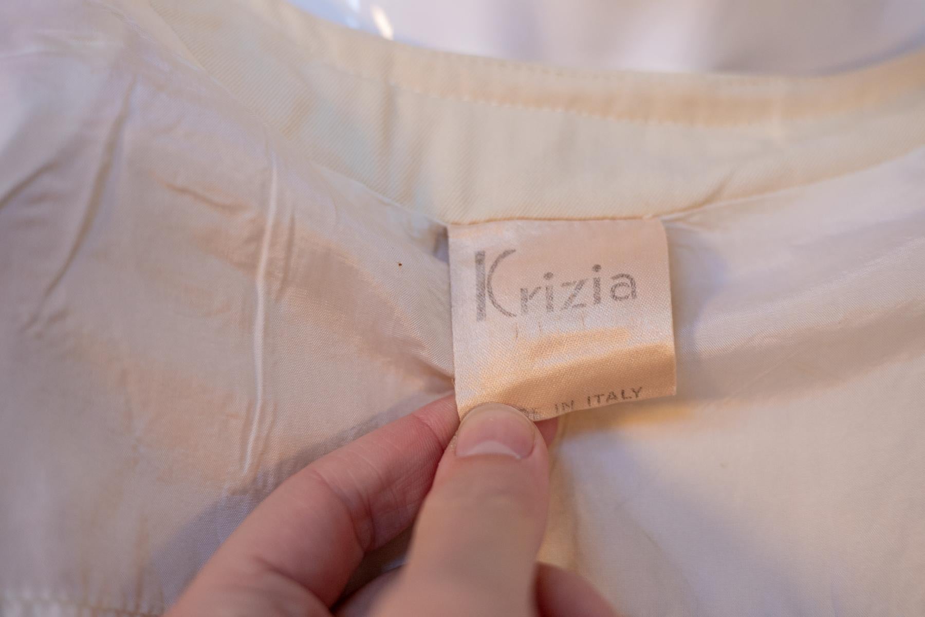Blouse chic en laine ivoire par Krizia des années 2000, fabriquée en Italie. ÉTIQUETTE ORIGINALE.
Le chemisier est entièrement réalisé en laine de couleur ivoire, avec un col en forme de U. La coupe est très droite et sévère. Les manches sont