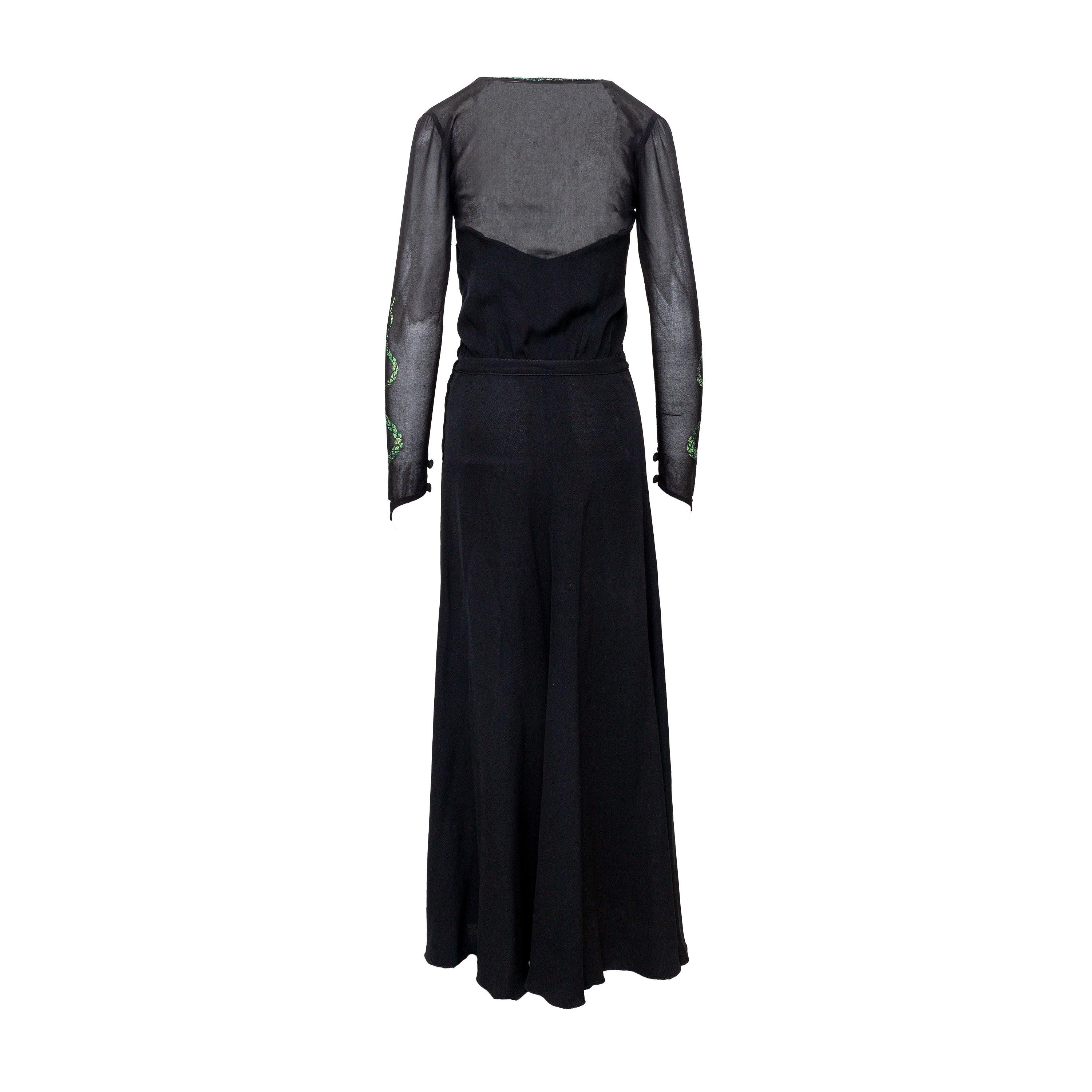 Step back in time with this stunning vintage black crepe dress by Krizia from the '70s. The hand painted gold and green glitter embellished snakes add a touch of boldness to the elegant fluid sleeves. With a fitted waist and hidden side zipper, this