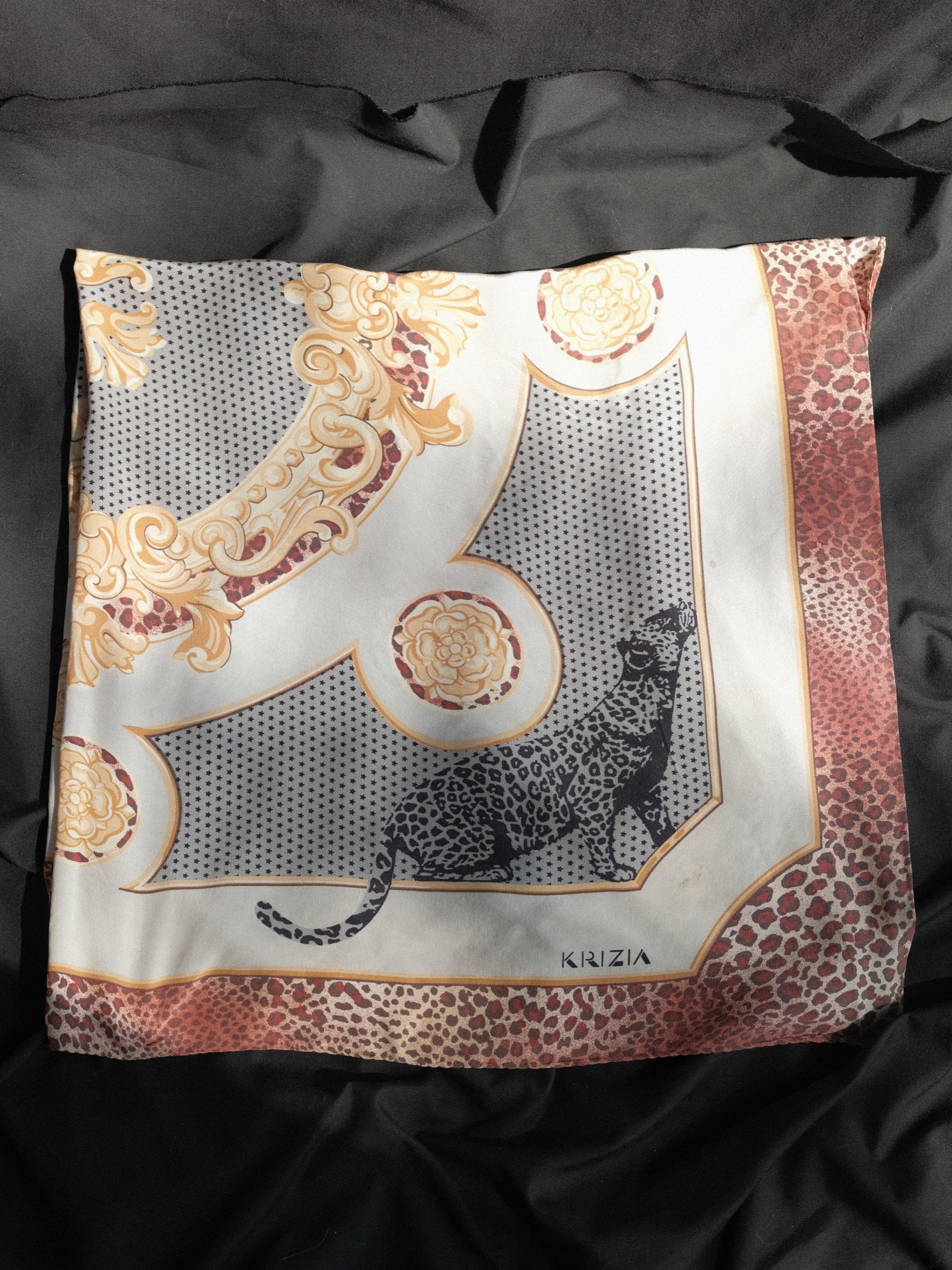 Krizia Silk Scarf 
Quintessential Krizia leopard motif, with star and floral background
Hand rolled edge
Silk Crepe de Chine, very soft, slightly matte finish
35 inches x 34 inches
Small marks near logo and right side of scarf, please refer to