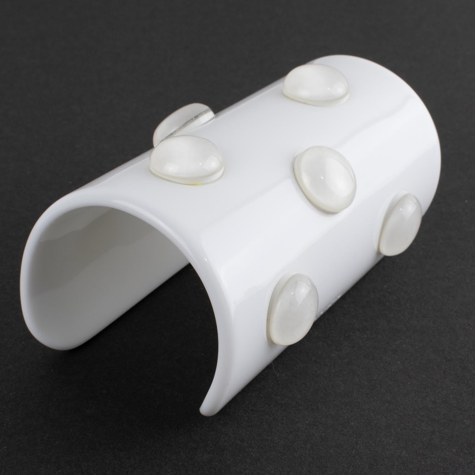 Krizia Italy designed this stunning lucite or acrylic bangle bracelet. The oversized cuff design features an opaque white cone shape. The color is unusual and glows in the dark. The cuff is adorned with transparent cabochons. The Krizia 