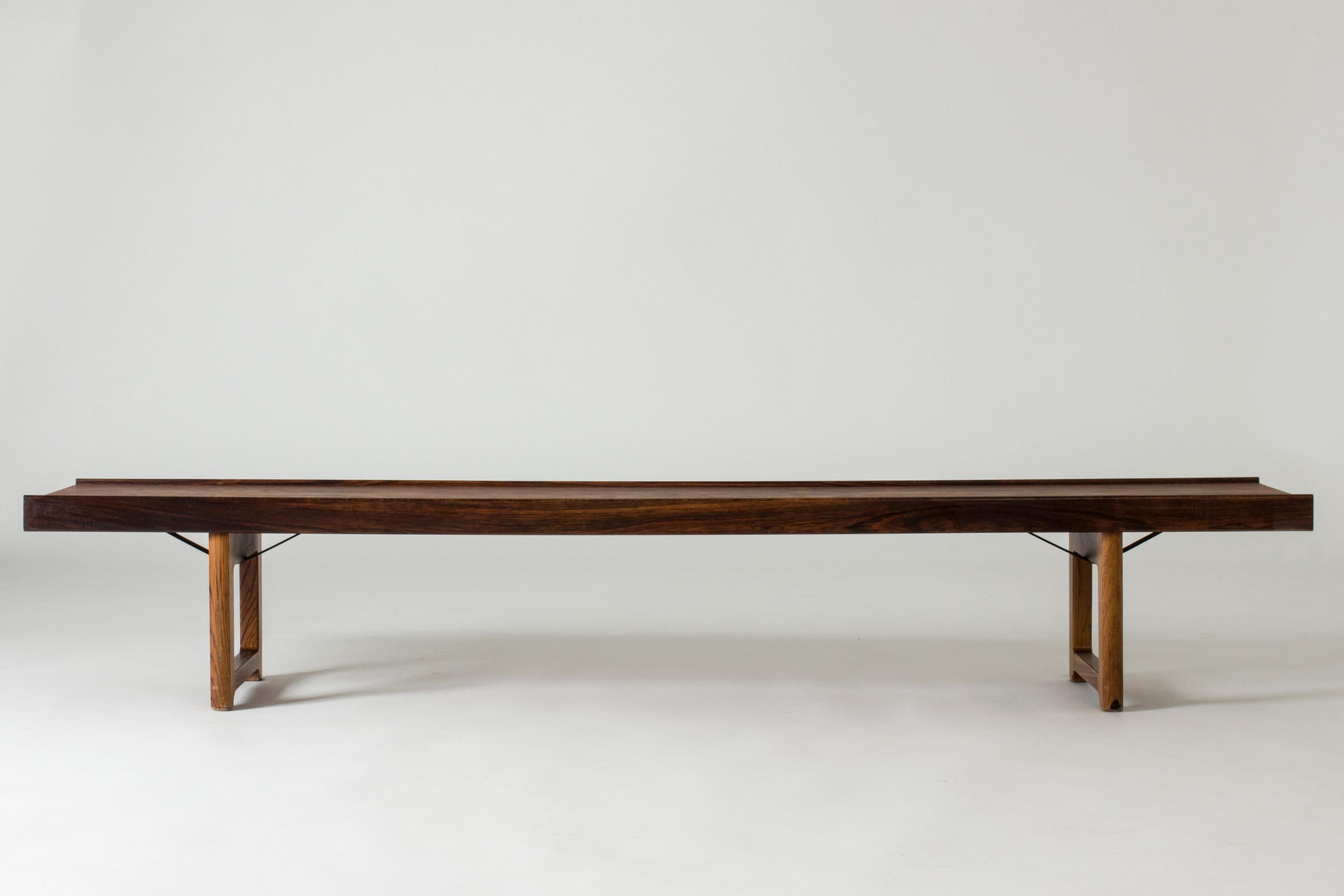 Sleek rosewood “Krobo” bench by Torbjørn Afdal, with black metal extenders underneath. Beautiful, dramatic veneer. Great as a coffee table or room divider.