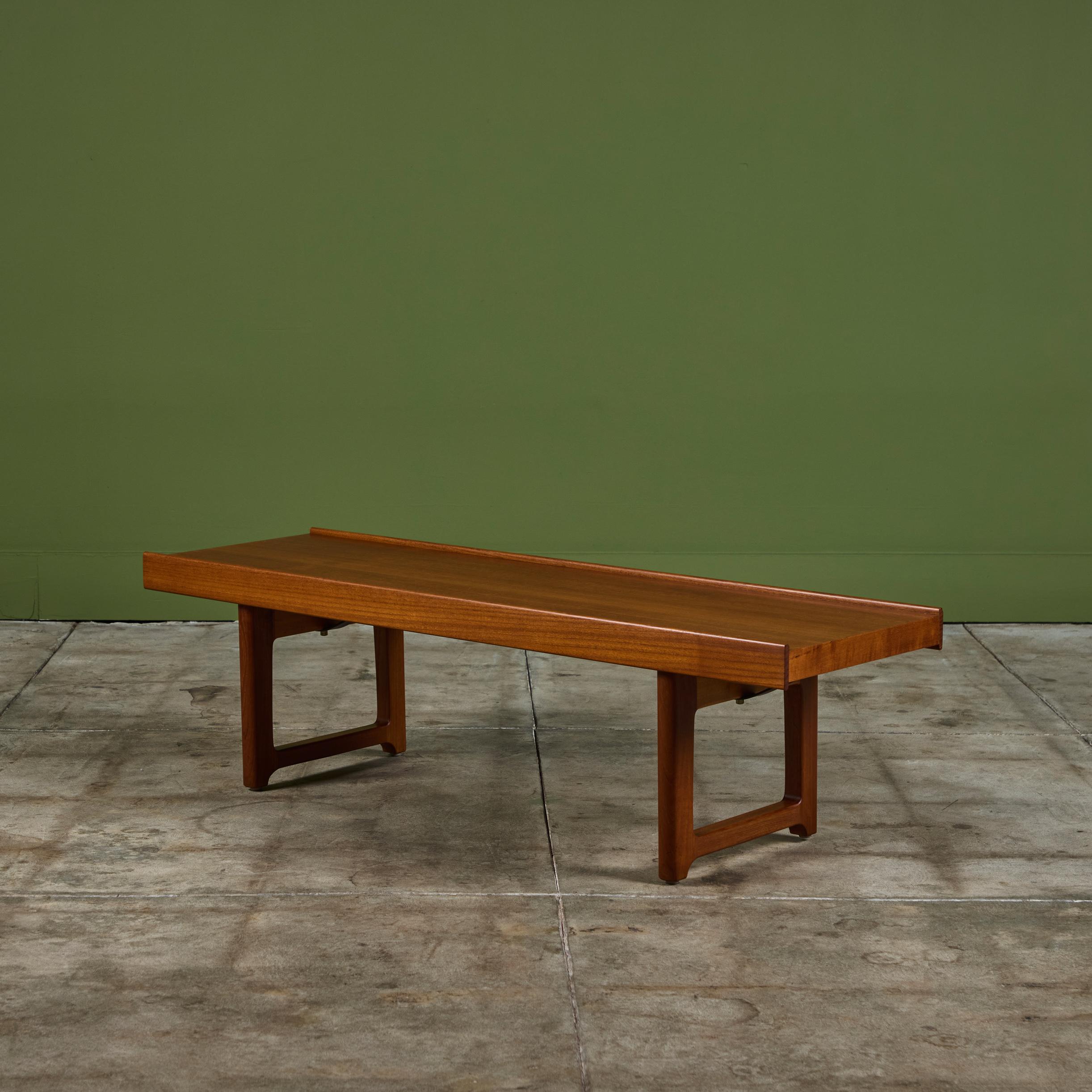 Rectangular low bench (or coffee table) by Torbjørn Afdal for Bruskbo of Norway, c.1950s. This example is executed in a beautiful Teak. The bench is supported by two runners, with angled steel supports.

Dimensions
47.5