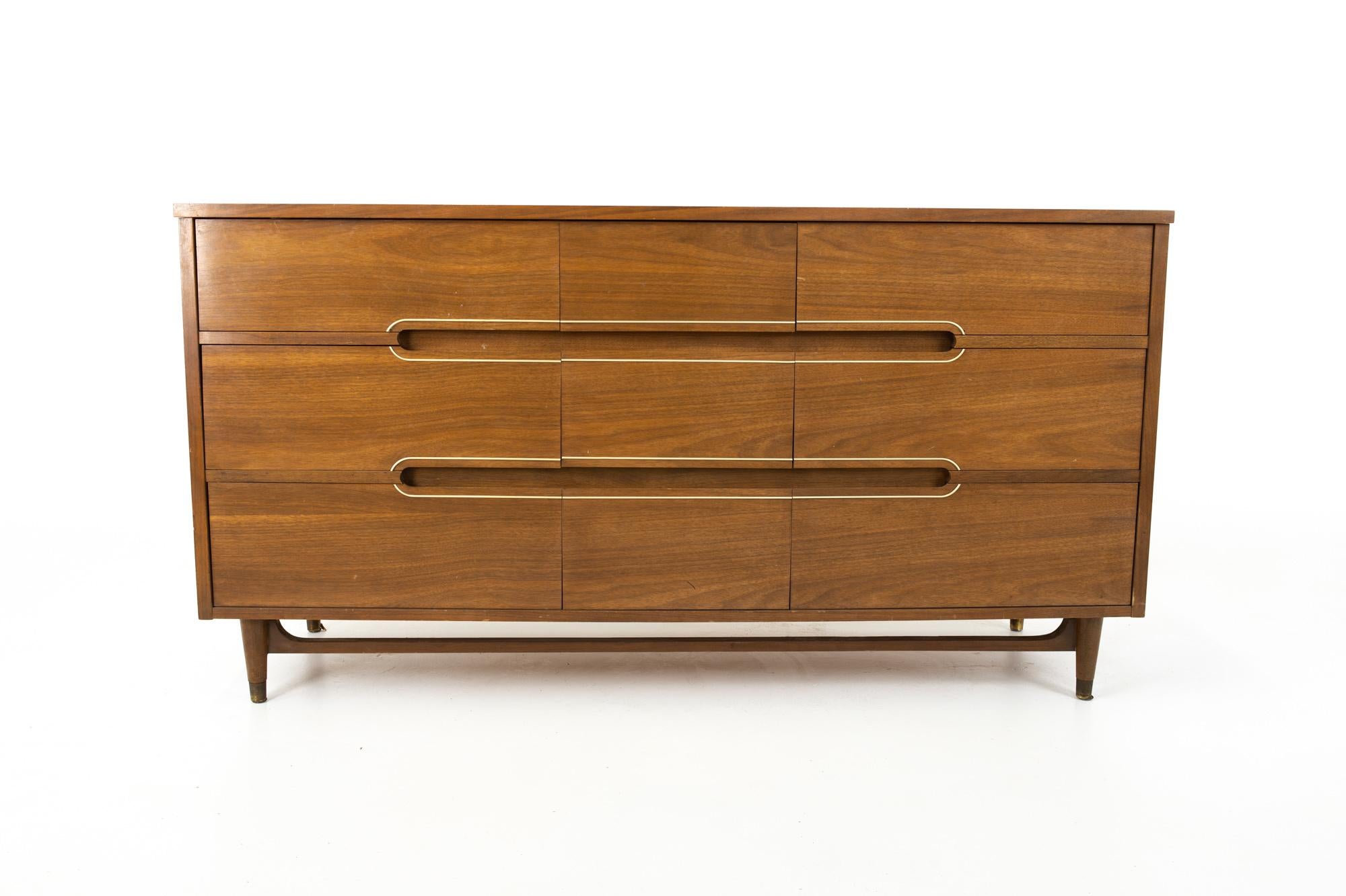 Kroehler Mid Century walnut and brass 9-drawer lowboy dresser
Dresser measure: 60.25 wide x 19 deep x 31.75 inches high

This price includes getting this piece in what we call restored vintage condition. That means the piece is permanently fixed