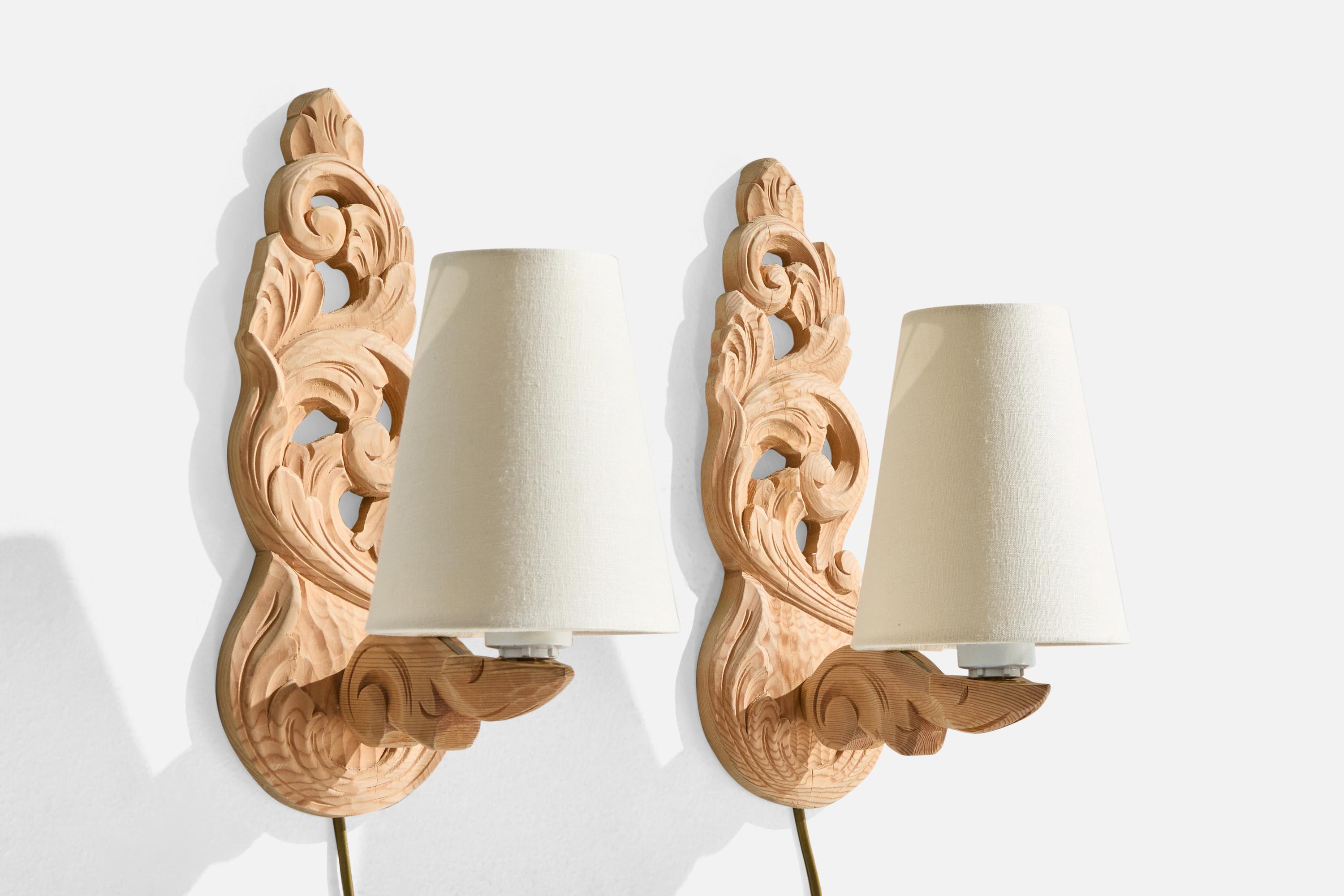 A pair of carved pine and white fabric wall lights designed and produced by Krogenæs Møbler, Norway, c. 1960s.

Brand new fabric lampshades.

Overall Dimensions (Inches): 12.625” H x 5 W x 8.25“ D

Back Plate Dimensions (Inches): 12.615” H x 4.75” W