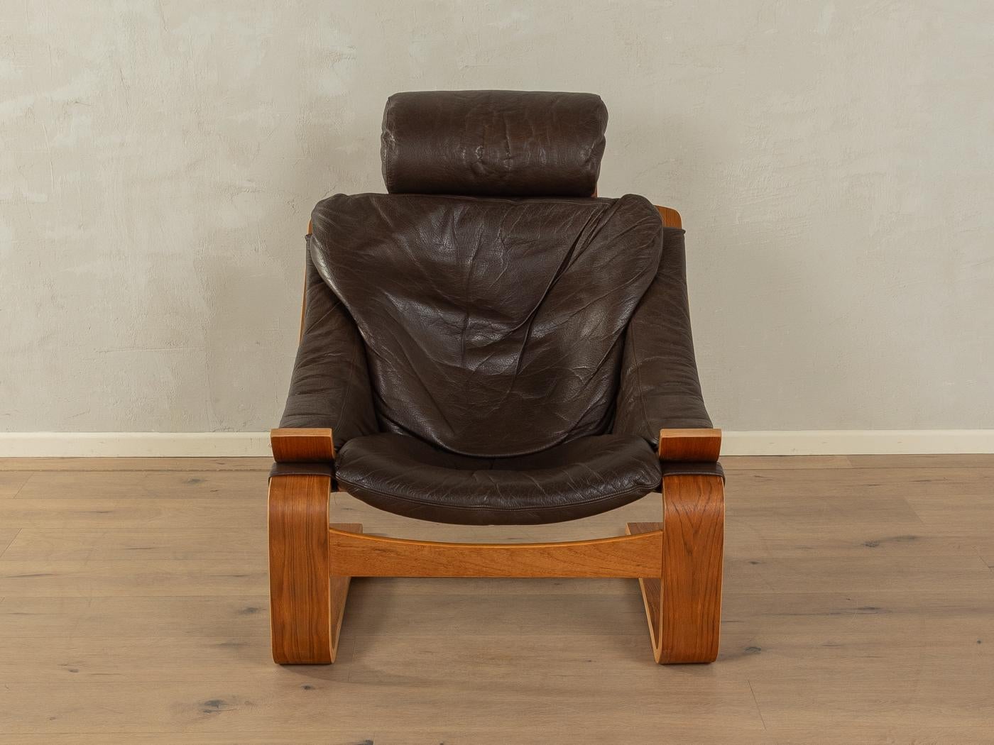 KROKEN Sessel mit Fußhocker von Ake Fribytter für NELO aus den 1970er Jahren. Hochwertiger Massivholzrahmen aus Eichenbugholz  in Teakholzfurnier mit dem hochwertigen Originalbezug aus dunkelbraunem Leder.
Qualitätsmerkmale:

    vollendetes Design: