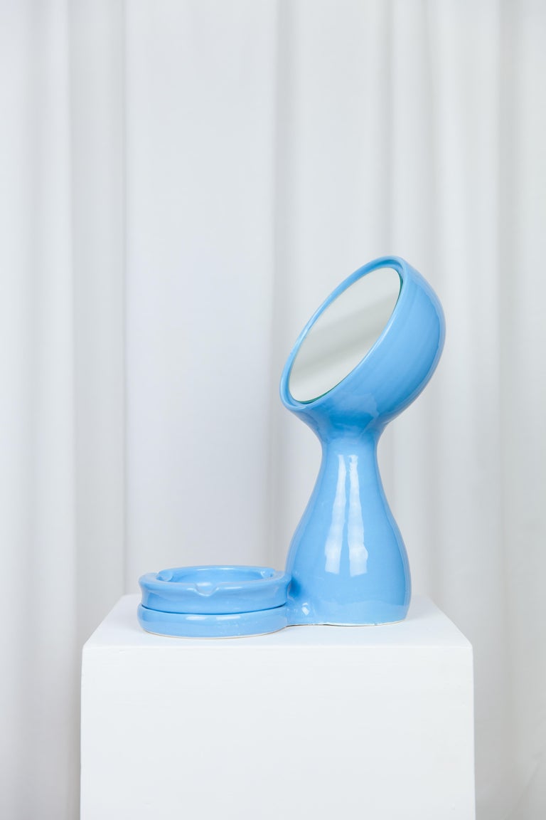 Kroli mirror + ashtray by Lola Mayeras
Dimensions: D 25 x W 16 x W 36 cm
Materials: Earthenware, mirror

Mirror with detachable ashtray in white earthenware, glazed blue.
This piece is designed and handcrafted in the south of France.

Lola
