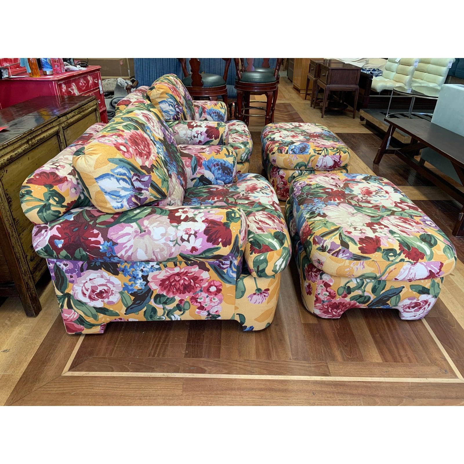 Presents a pair of custom lounge chairs and ottomans by Kroll Furniture. The frame is crafted from solid wood. Rolled arms with a rolled back. Upholstered from bottom to top in a vibrant floral print fabric. Consist of a loose seat and back cushion