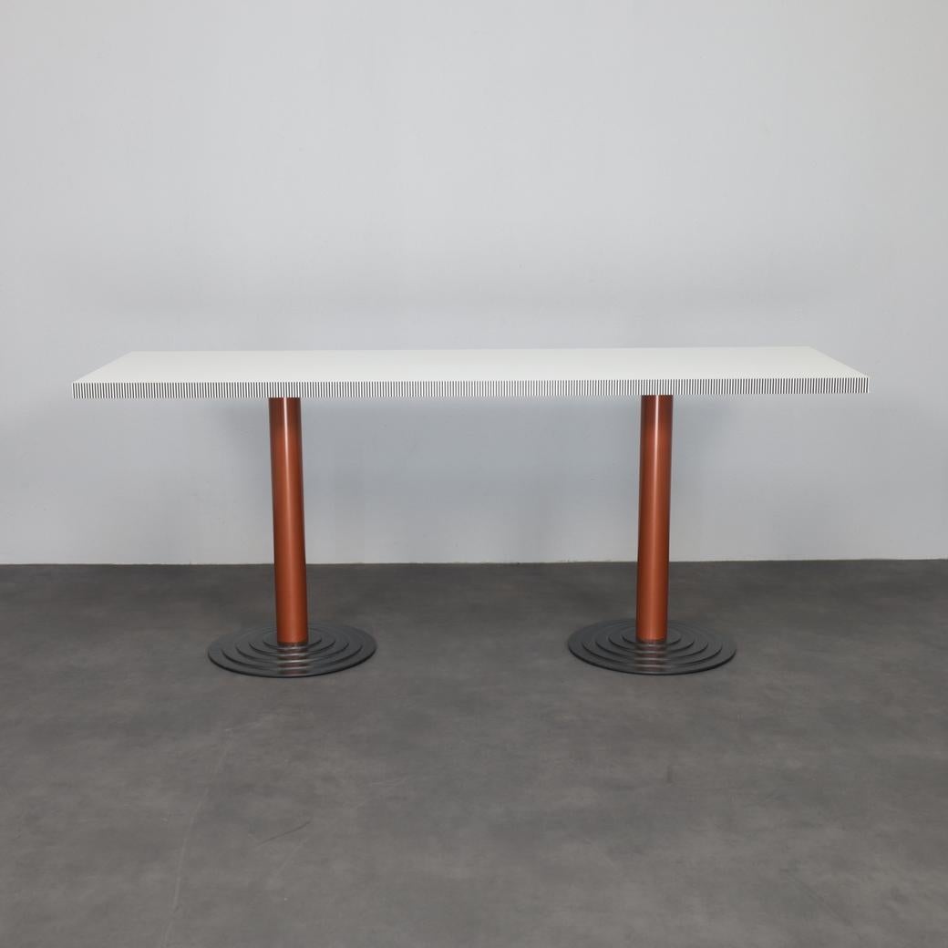 Designed by Antonia Astori for Driade, the ‘Kroma’ table is a quintessential expression of Italian postmodernism — bold, architectural, and immaculately balanced. The design pairs a crisp white top with finely striped edges and cylindrical