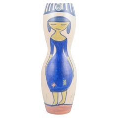 Krukmakaren, Ystad. Vase en céramique orné d'un motif représentant une femme en robe bleue. Années 1970