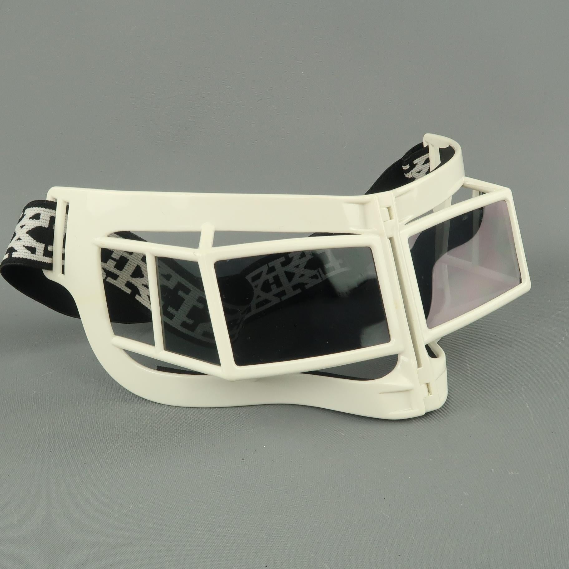 KTZ ski goggles mask style sunglasses by LINDA FARROW feature a white acetate geometric cage shape, rectangular polarized lenses, padded interior, logo elastic band, and collapsible folding hinged center. With box.
 
Excellent Pre-Owned Condition.
