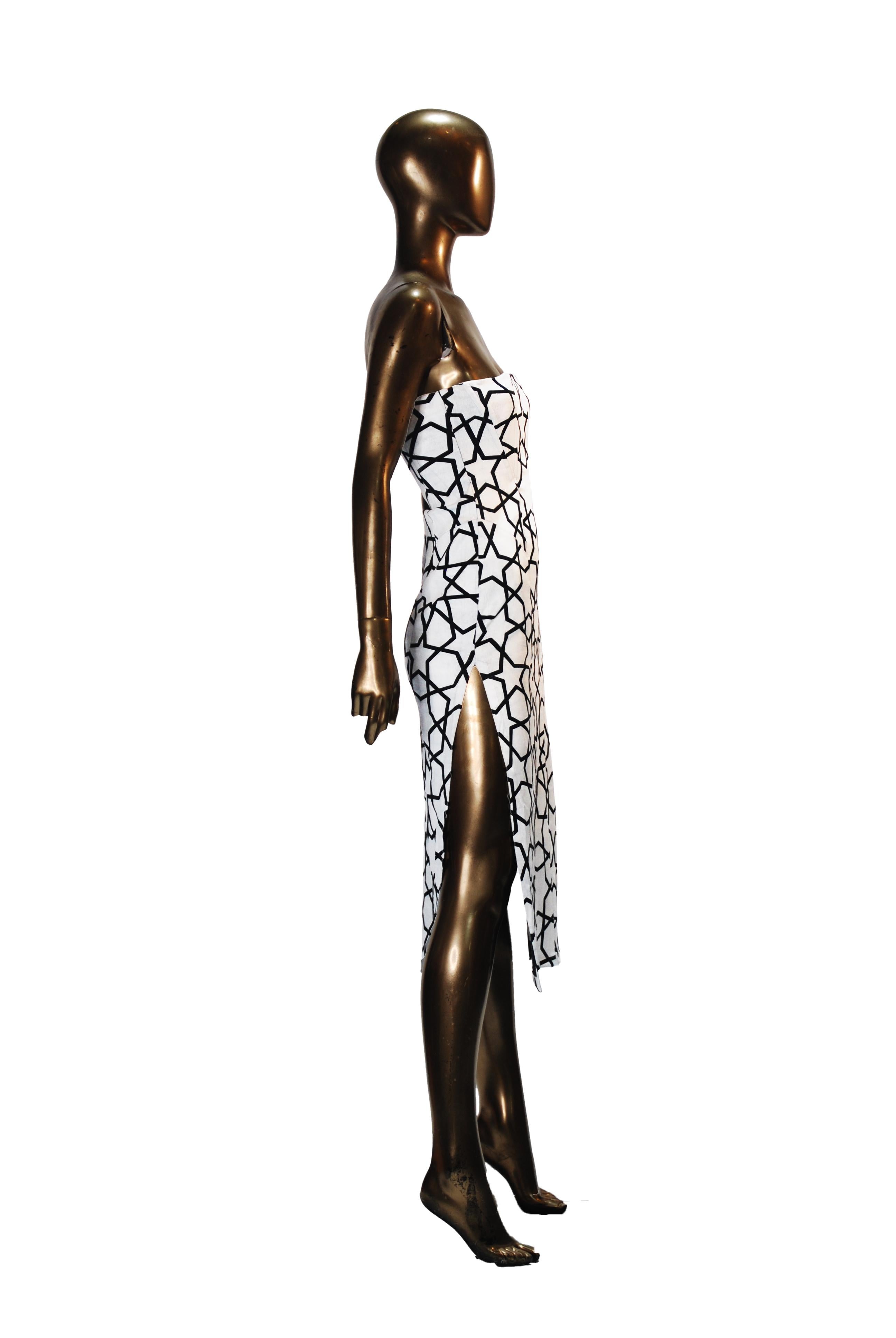 Designed by cult-favourite label KTZ, this corseted strapless evening dress makes a bold visual statement with its striking black stars on a crisp white base.The minimalist, body skimming silhouette is crafted from a high-quality blend of 95% cotton